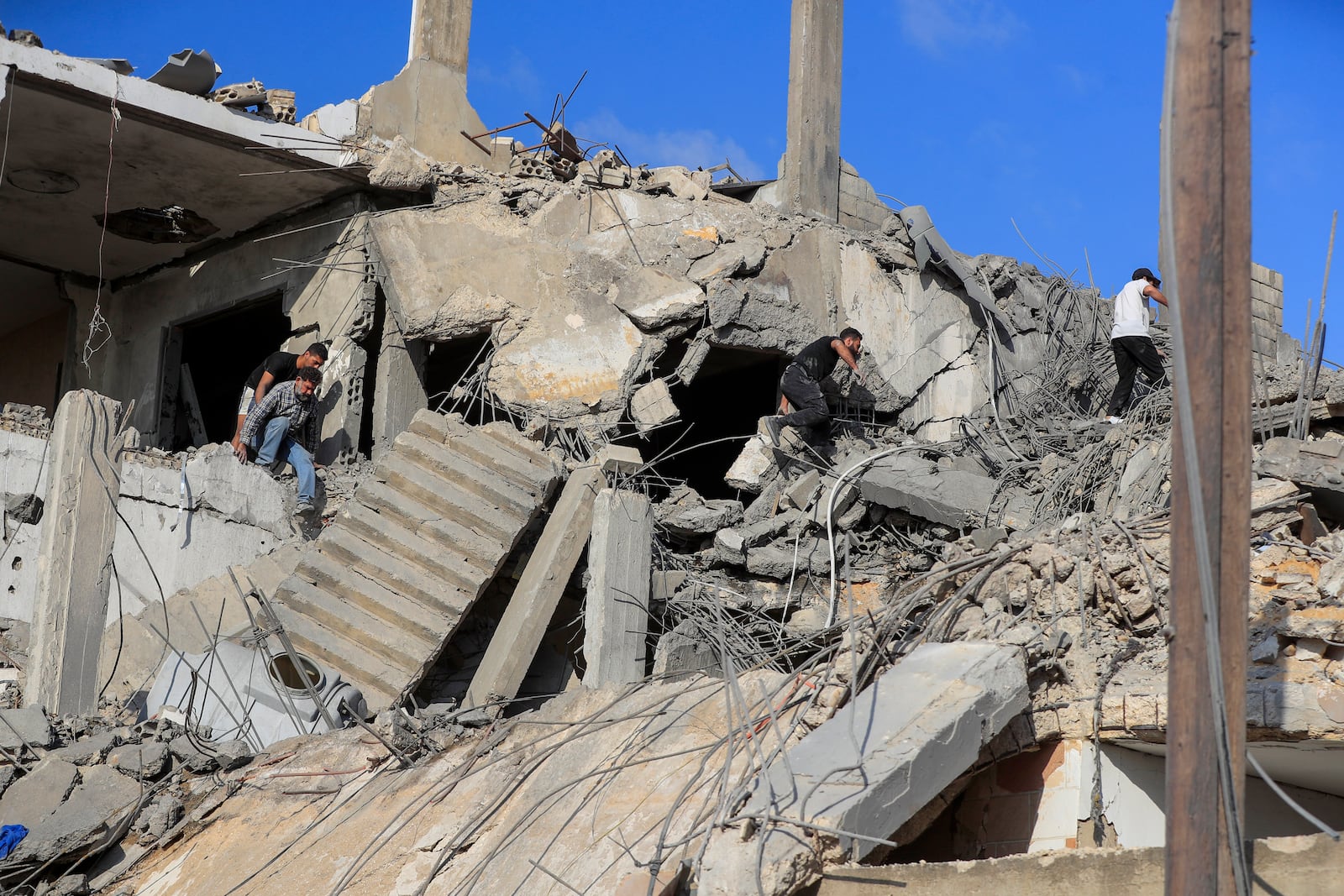 People search for victims at a destroyed building hit in an Israeli airstrike, in Ghaziyeh town, south Lebanon, Sunday, Nov. 3, 2024. (AP Photo/Mohammed Zaatari)