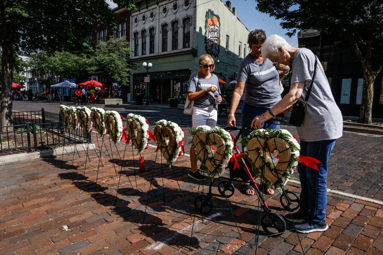 The family of Oregon District shooting victim Logan Turner, from left Kathy Turner, Susan Scherbauer and Chris Wuebben, visit the memorial for the nine victims Friday, Aug. 4, 2023, during a remembrance on the fourth anniversary. JIM NOELKER/STAFF