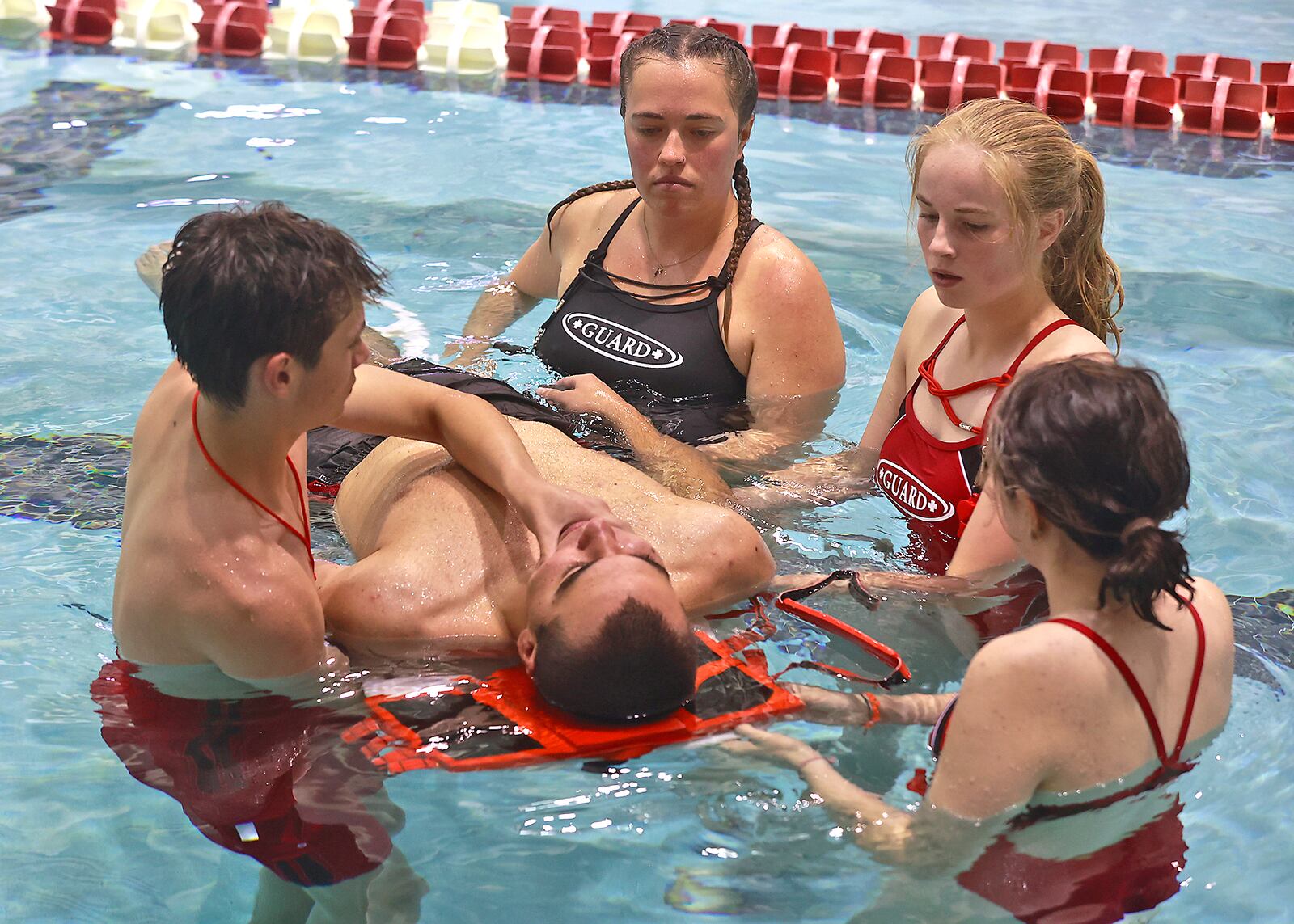 Splash Zone Aquatic Center lifeguards practices saving a swimmer with a spinal injury Thursday, May 18, 2023 in the pool at Wittenberg University. The lifeguards have been busy training so they're ready for the opening of Splash Zone on Memorial Day weekend. BILL LACKEY/STAFF