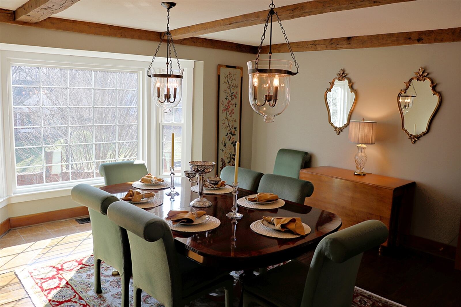 Wood beams stretch across the dining room ceiling and blend into the crown molding. 