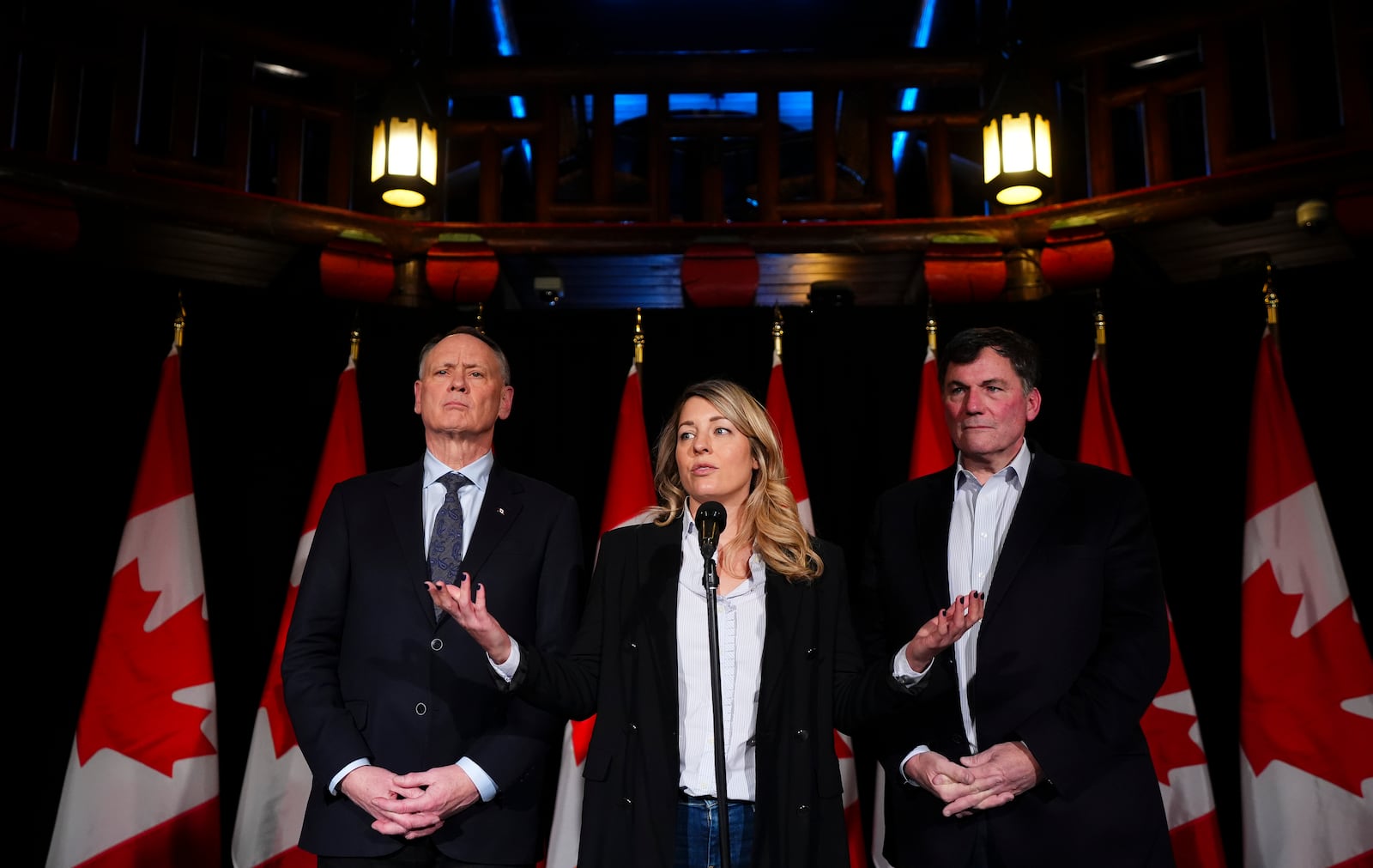 Canada's Minister of Foreign Affairs Melanie Joly is flanked by Minister of Public Safety David McGuinty, left, and Minister of Finance and Intergovernmental Affairs Dominic LeBlanc, as they speak to reporters prior to a meeting during a cabinet retreat at Chateau Montebello in Montebello, Quebec, on Monday, Jan. 20, 2025. (Sean Kilpatrick/The Canadian Press via AP)