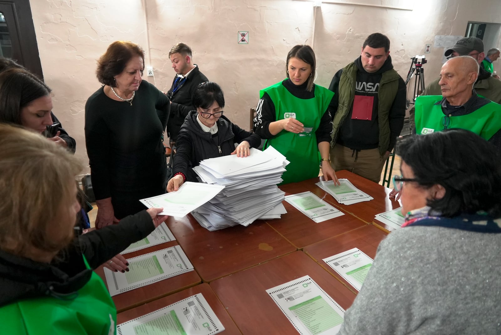 Members of an election commission count ballots at a polling station after the parliamentary election in Tbilisi, Georgia, Saturday, Oct. 26, 2024. (AP Photo/Kostya Manenkov)