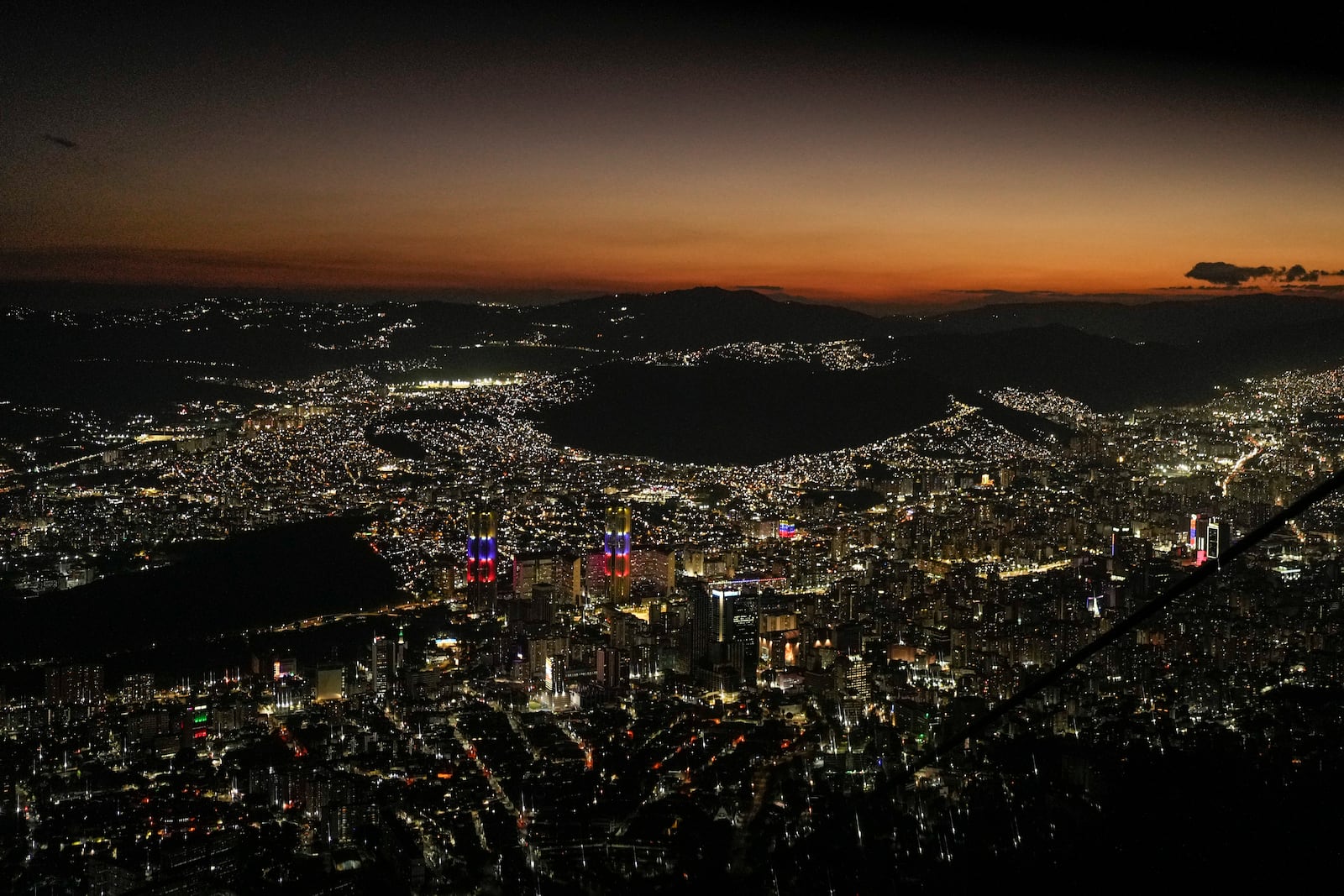 Night falls on Caracas, Venezuela, as seen from El Avila, Wednesday, Jan. 8, 2025, days ahead of President Nicolas Maduro's inauguration for a third presidential term. (AP Photo/Matias Delacroix)