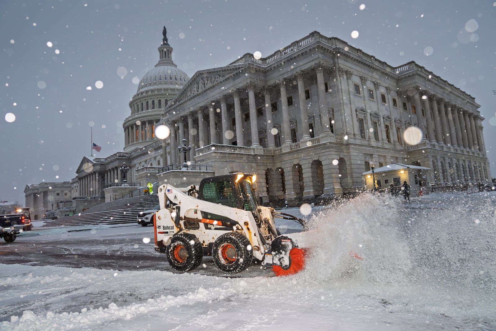 Workers clear the plaza at the Capitol as snow falls ahead of a joint session of Congress to certify the votes from the Electoral College in the presidential election, in Washington, Monday, Jan. 6, 2025. (AP Photo/J. Scott Applewhite)