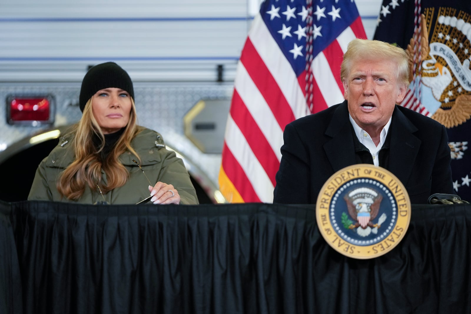 President Donald Trump is briefed on the effects of Hurricane Helene at Asheville Regional Airport in Fletcher, N.C., Friday, Jan. 24, 2025, as first lady Melania Trump looks on. (AP Photo/Mark Schiefelbein)