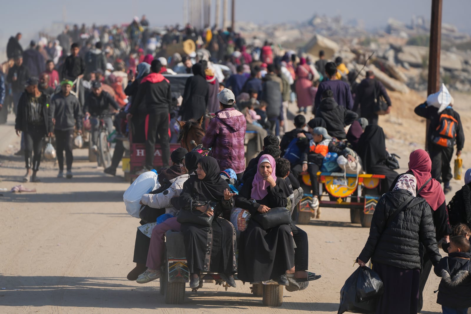 Displaced Palestinians walk on a road in central Gaza to return to their homes in the northern Gaza Strip, Wednesday, Jan. 29, 2025. (AP Photo/Abdel Kareem Hana)