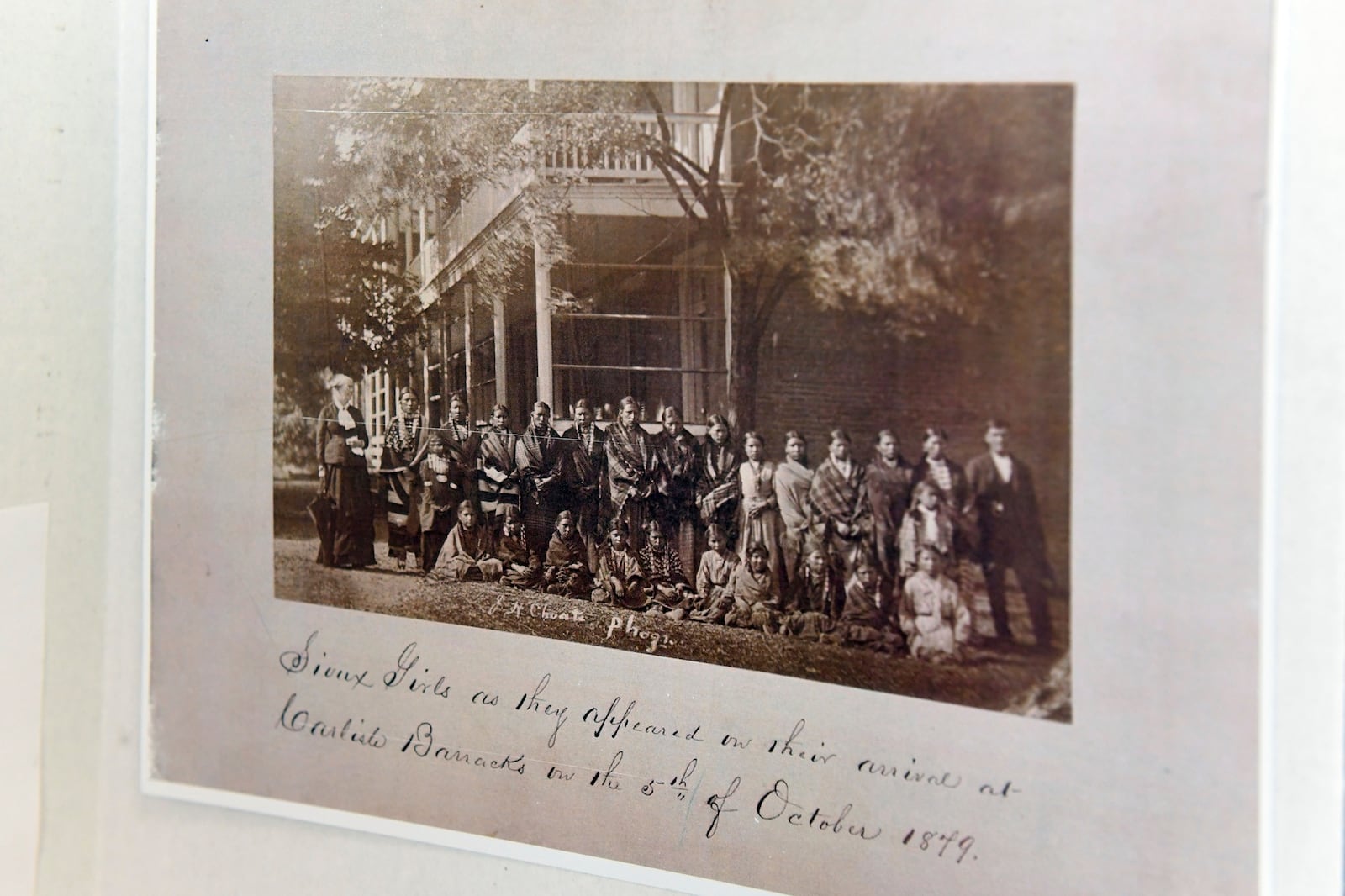 FILE - A poster about the history of Carlisle Indian Reform School includes a historical photo of Sioux girls upon arrival from their homes to the boarding school on Saturday, July 17, 2021 at the Sinte Gleska University Student Multicultural Center in Rosebud, S.D. (Erin Bormett/The Argus Leader via AP, File)