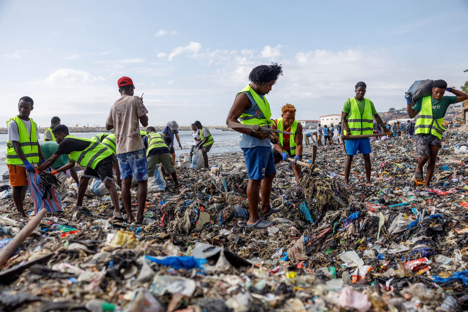 Volunteers and workers for the OR Foundation partake in a beach clean up at Jamestown in Accra, Ghana, Saturday, Oct. 19, 2024. (AP Photo/Misper Apawu)