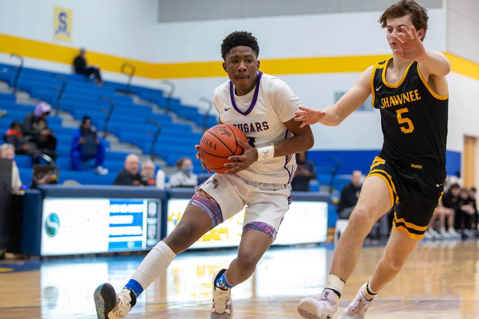 Thurgood Marshall High School senior Renald Person III drives by Shawnee senior Cody Siemon during their game on Wednesday night at Springfield High School. The Braves won 50-45. Michael Cooper/CONTRIBUTED