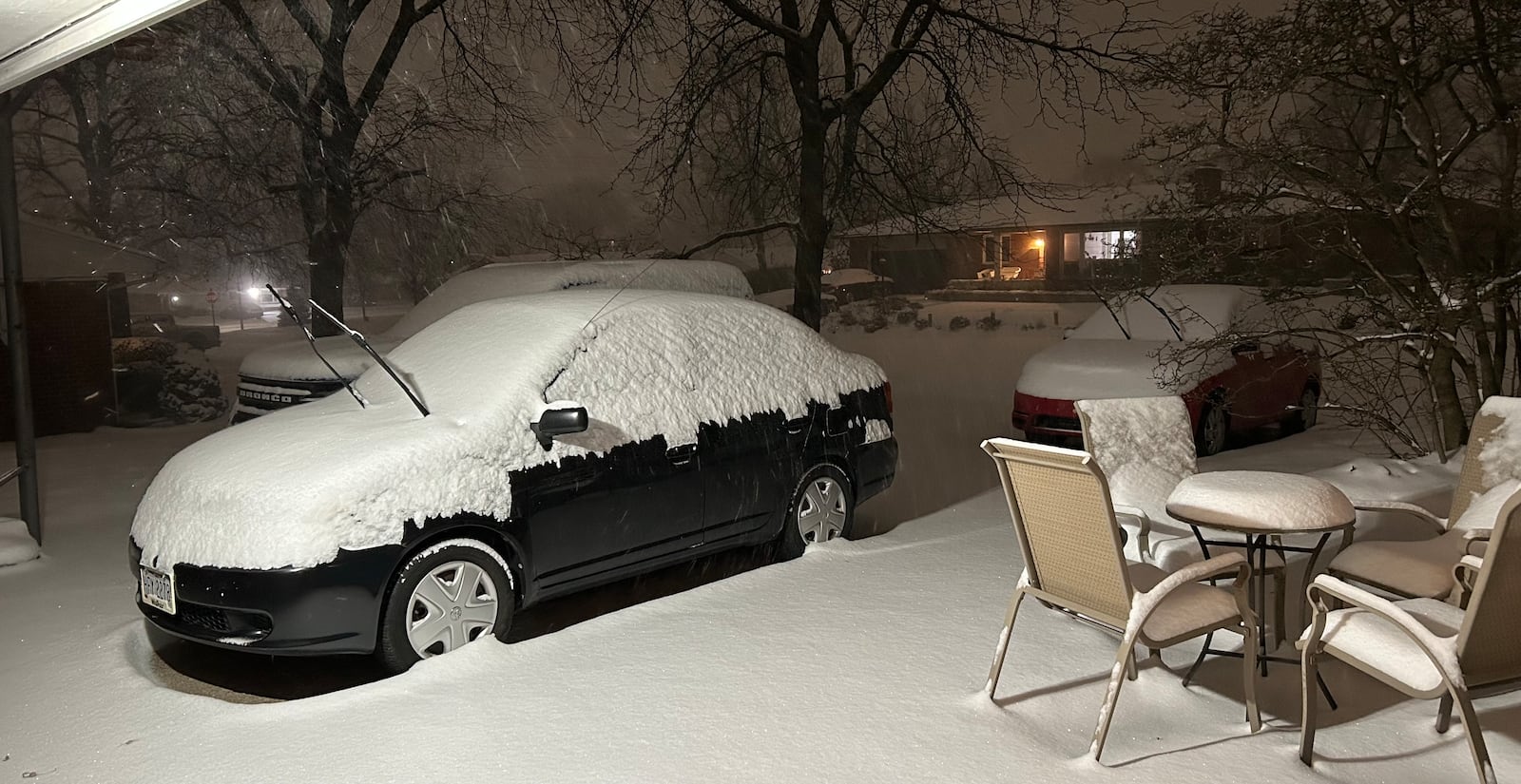 Photo 1 of 2: Snow piles up on cars and patio furniture in Kettering around 8 p.m. Sunday, Jan. 5, 2025. Jeremy P. Kelley/Staff