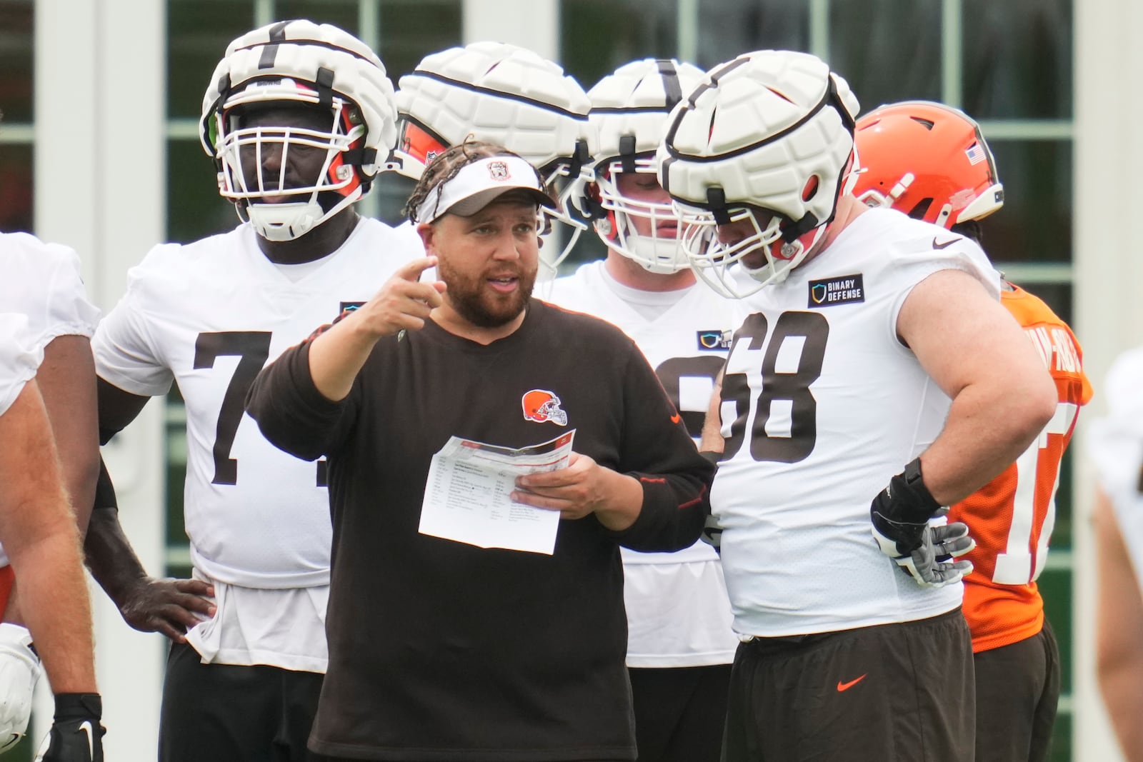 FILE - Andy Dickerson, Cleveland Browns offensive line coach, talks with Michael Dunn (68) during an NFL football training camp practice in White Sulphur Springs, West Virginia, Thursday, July 25, 2024. (AP Photo/Sue Ogrocki, File)