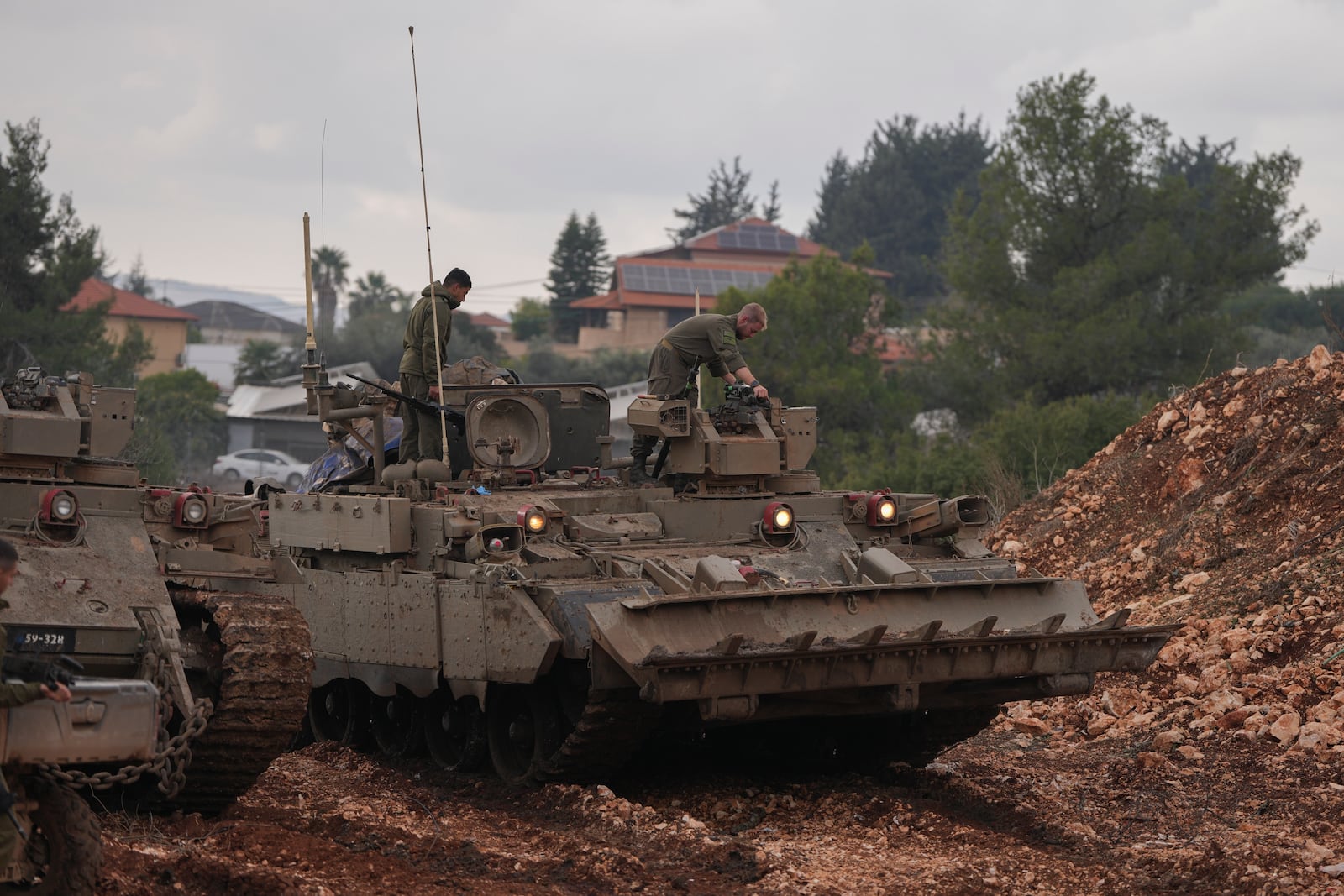 Israeli soldiers stand atop army armoured vehicles outside the agricultural settlement of Avivim, next to the Lebanese border in upper Galilee, Israel, Thursday Nov 28, 2024. (AP Photo/Ohad Zwigenberg)