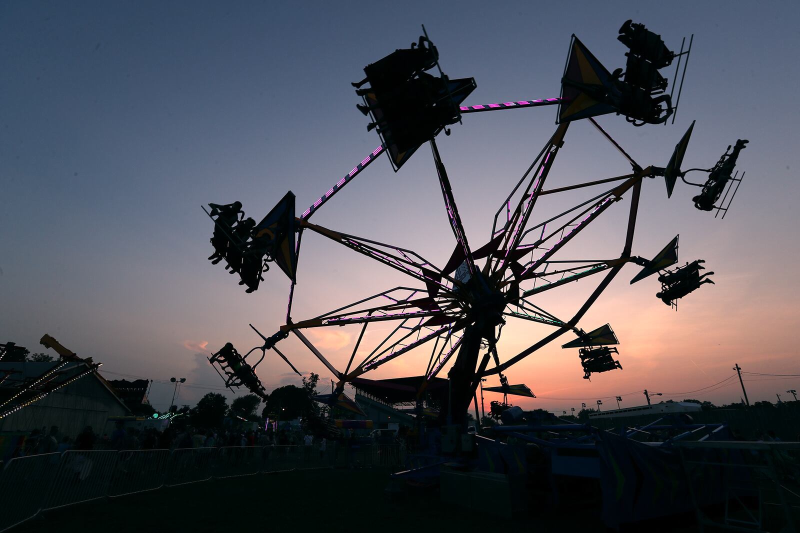 The Hang Glider ride is silhouetted against the sunset Sunday on the midway at the Champaign County Fair in 2021. BILL LACKEY/STAFF