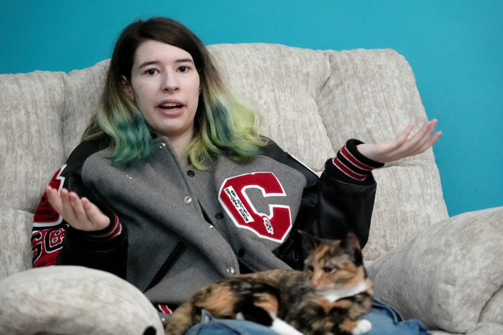 Zoe Reiland, 17, sits with her cat, Cracker, and talks about she and her younger brother being monitored at their previous schools, in Oklahoma, by surveillance technology, Monday, March 10, 2025, in Clinton, Miss.(AP Photo/Rogelio V. Solis)