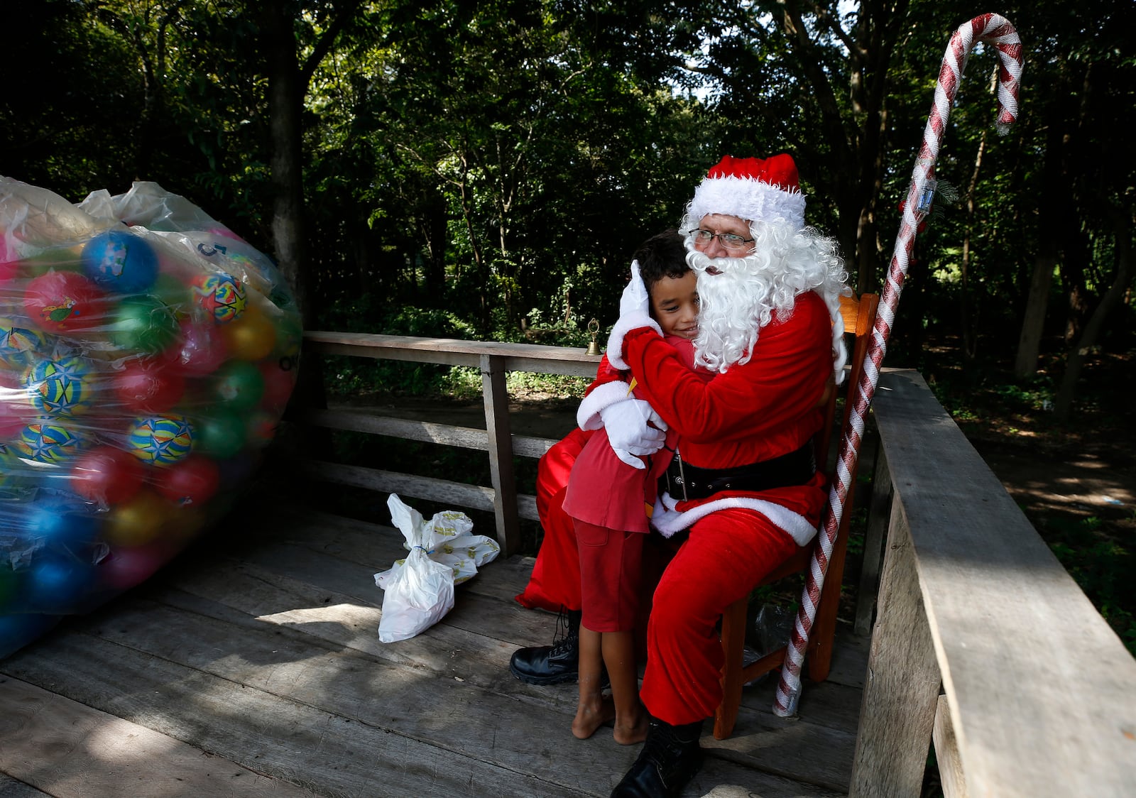 Jorge Barroso, dressed as Santa Claus, is embraced by a young resident after arriving on a boat to distribute Christmas gifts to children who live in the riverside communities of the Amazon, in Iranduba, Brazil, Saturday, Dec. 21, 2024. (AP Photo/Edmar Barros)