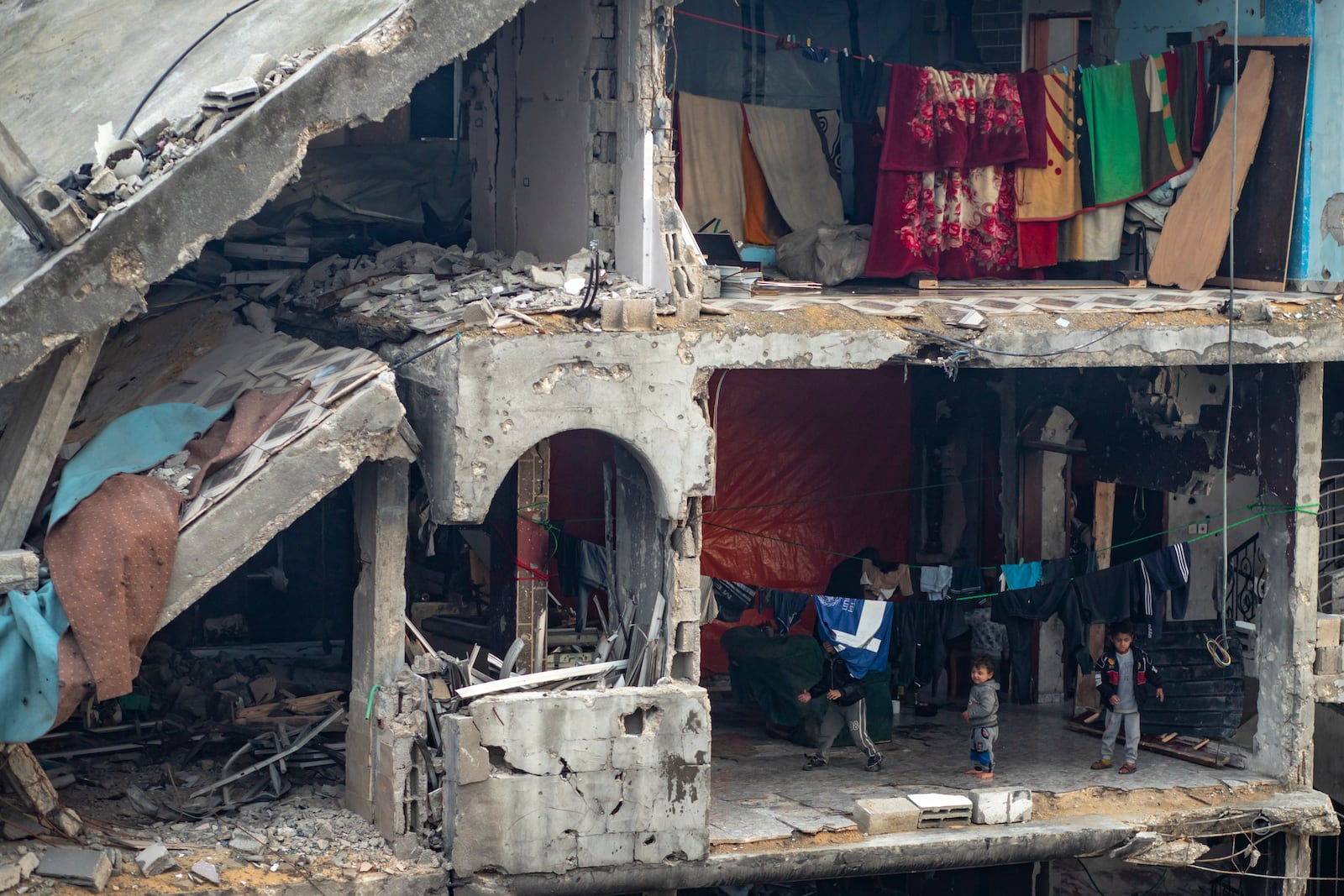 Palestinian children play in a partially standing home, in an area largely destroyed by the Israeli army's air and ground offensive in Jabaliya, Gaza Strip, on Tuesday, Feb. 11, 2025. (AP Photo/Jehad Alshrafi)