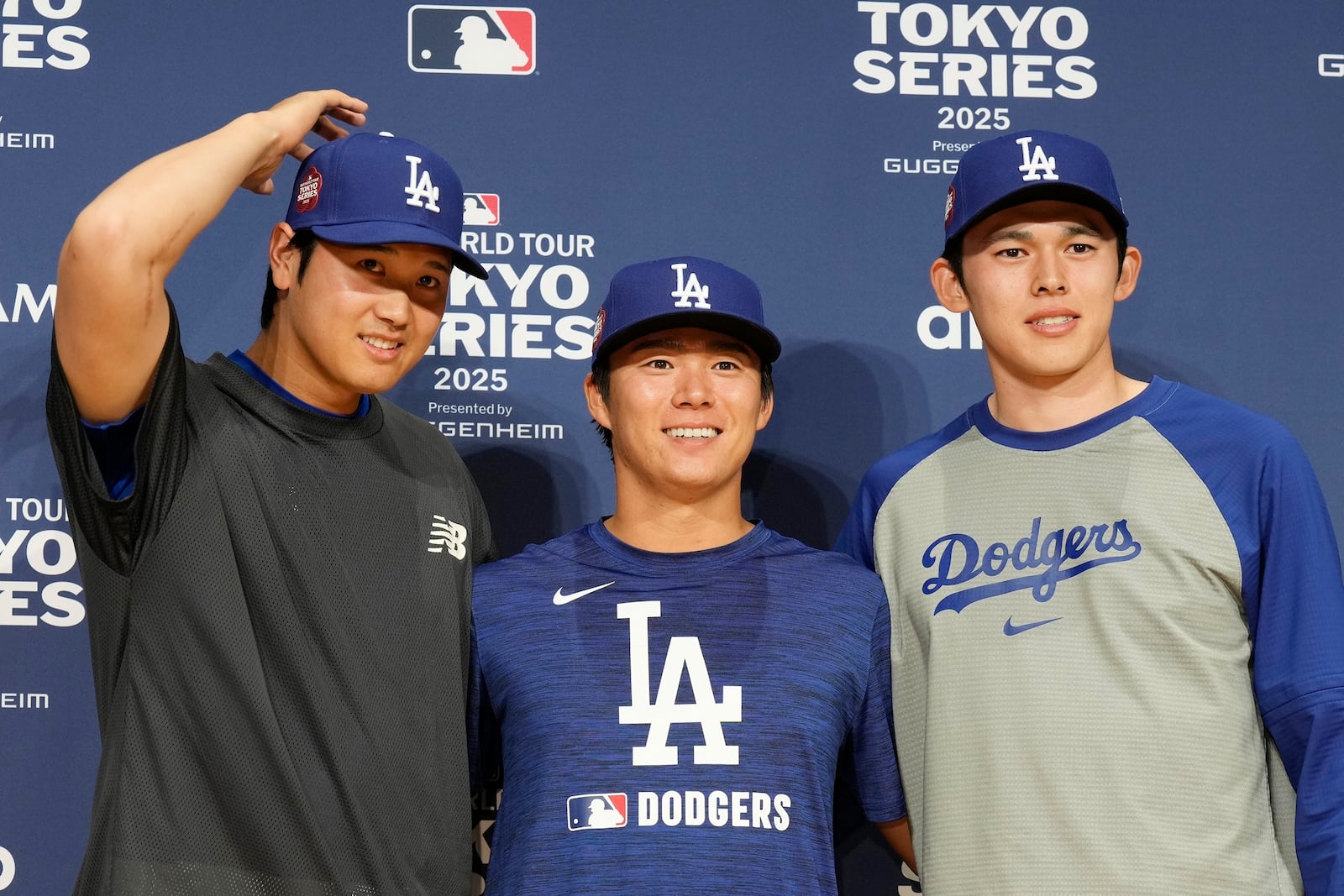 Los Angeles Dodgers Shohei Ohtani, left, Yoshinobu Yamamoto, center, and Roki Sasaki, right, pose for photographs during the official Press conference Friday, March 14, 2025, in Tokyo, as the Dodgers play their MLB opening games against the Chicago Cubs at Tokyo Dome next week. (AP Photo/Eugene Hoshiko)