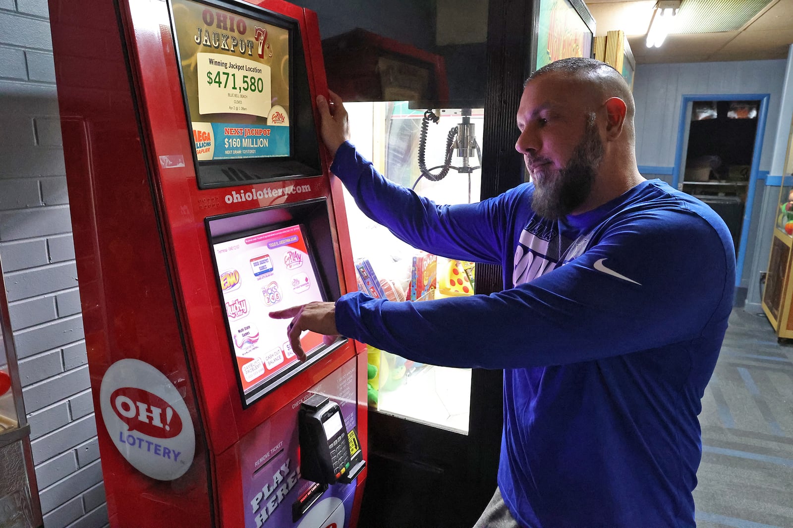 Demetri Zavakos, manager of Victory Lanes bowling alley in Springfield, describes how sports betting will work on an Ohio Lottery kiosk in the alley Thursday. BILL LACKEY/STAFF