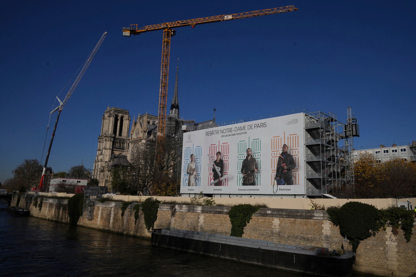 Cranes and workers' facilities are seen behind Notre-Dame cathedral, Thursday, Nov. 28, 2024 in Paris. (AP Photo/Michel Euler)