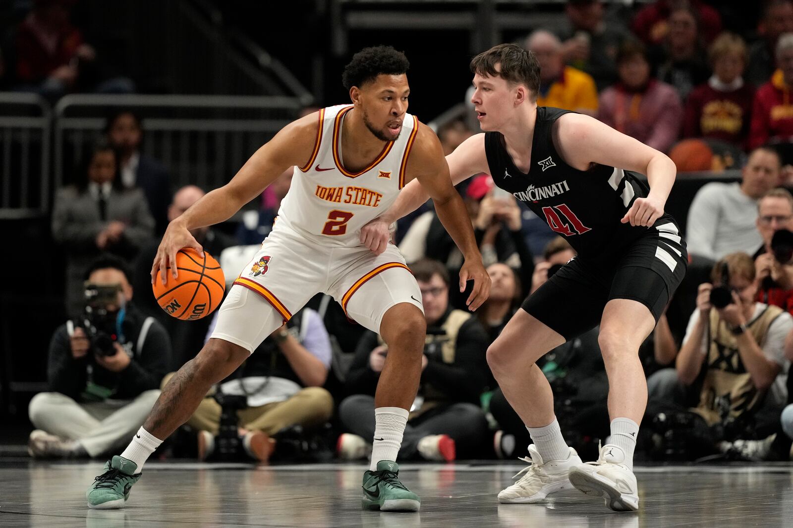 Iowa State's Joshua Jefferson (2) dribbles around Cincinnati's Simas Lukosius (41) during the first half of an NCAA college basketball game in the second round of the Big 12 Conference tournament, Wednesday, March 12, 2025, in Kansas City, Mo. (AP Photo/Charlie Riedel)