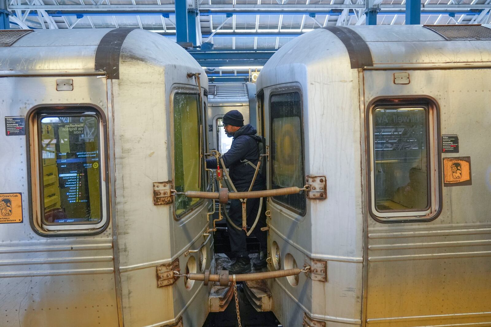 A train conductor walks between subway cars at a station in the Coney Island section of New York, Thursday, Jan. 23, 2025. (AP Photo/Seth Wenig)