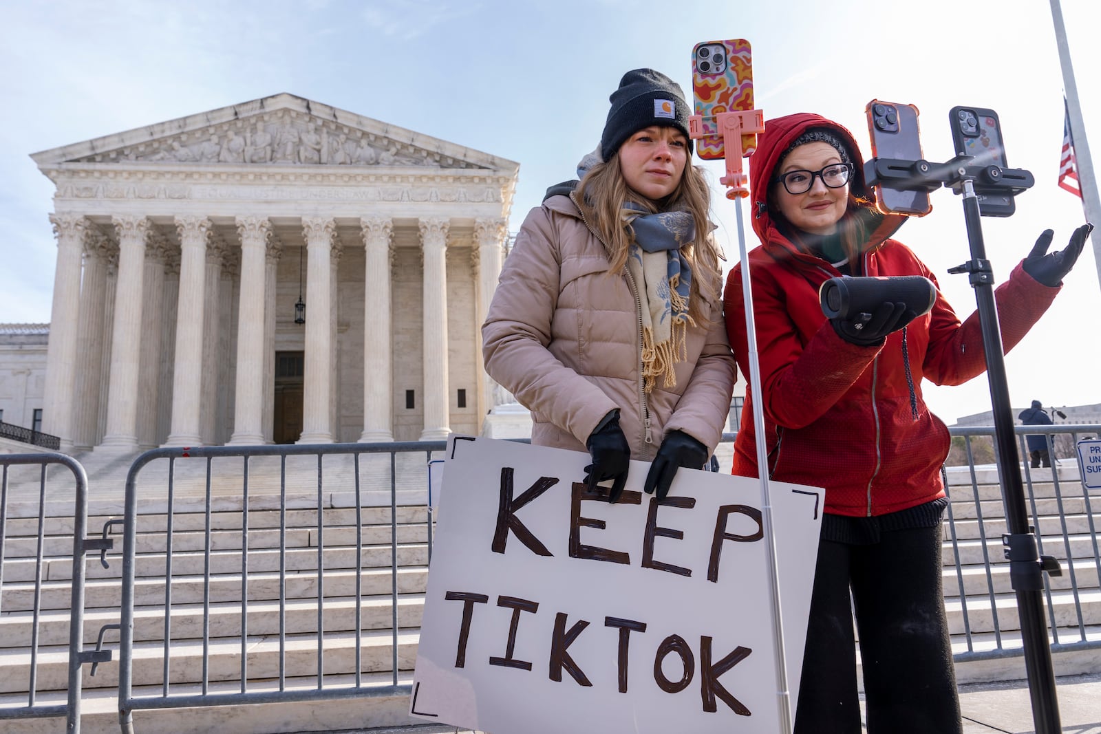 FILE - Sarah Baus, left, of Charleston, S.C., and Tiffany Cianci, who says she is a "long-form educational content creator," livestream to TikTok outside the Supreme Court, on Jan. 10, 2025, in Washington. (AP Photo/Jacquelyn Martin, File)