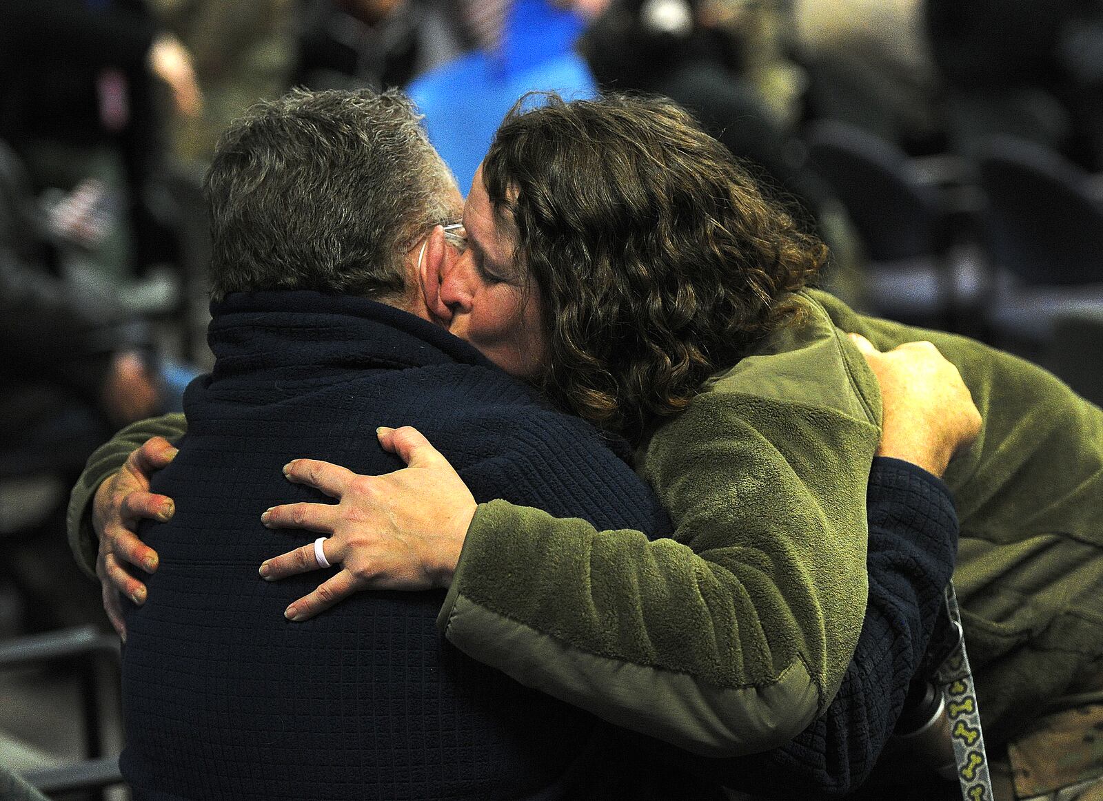 Caroline Sussman hugs her husband Larry, Thursday, Jan. 4, 2024 after she and 140 other airmen arrived home in a quartet of C-17 Globemaster cargo planes, the Airmen returned to Wright-Patterson Air Force Base from more than two months deployed at an undisclosed location. MARSHALL GORBY\STAFF