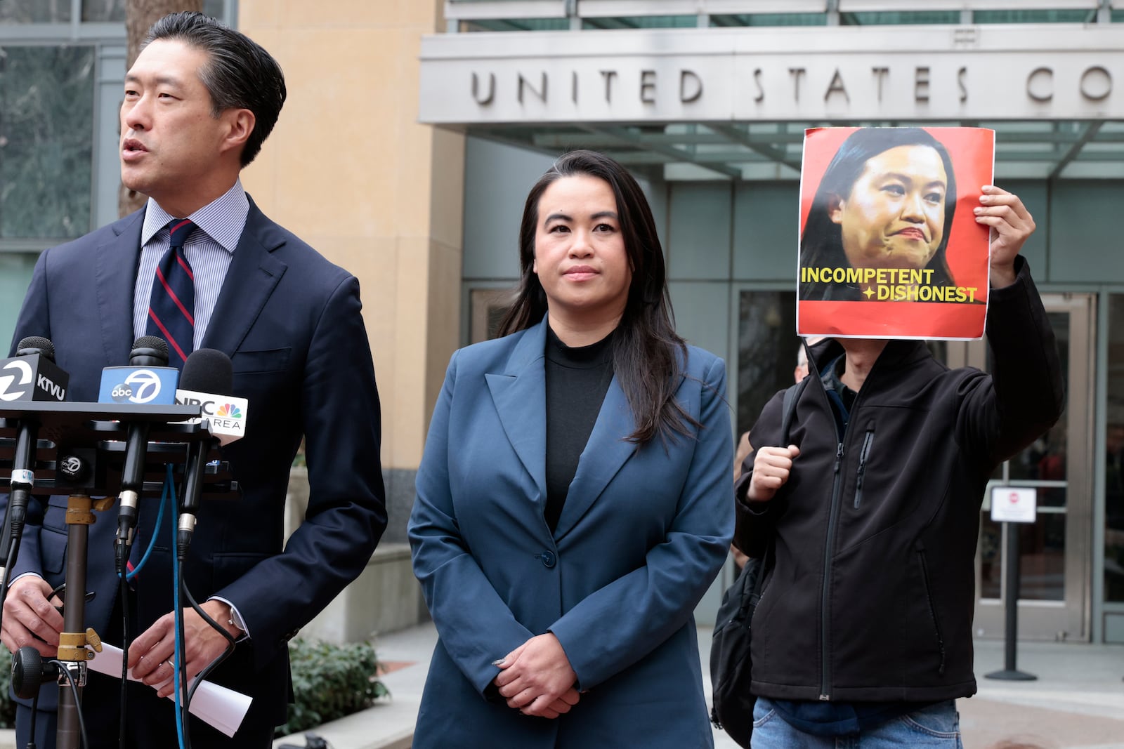 Former Oakland Mayor Sheng Thao stands next to her lawyer Jeff Tsai outside the United States District Court after a hearing in Oakland, Calif., Friday, Jan. 17, 2025, as Tuan Ngo, founder of Asians Unite, protests at right. (Santiago Mejia/San Francisco Chronicle via AP)