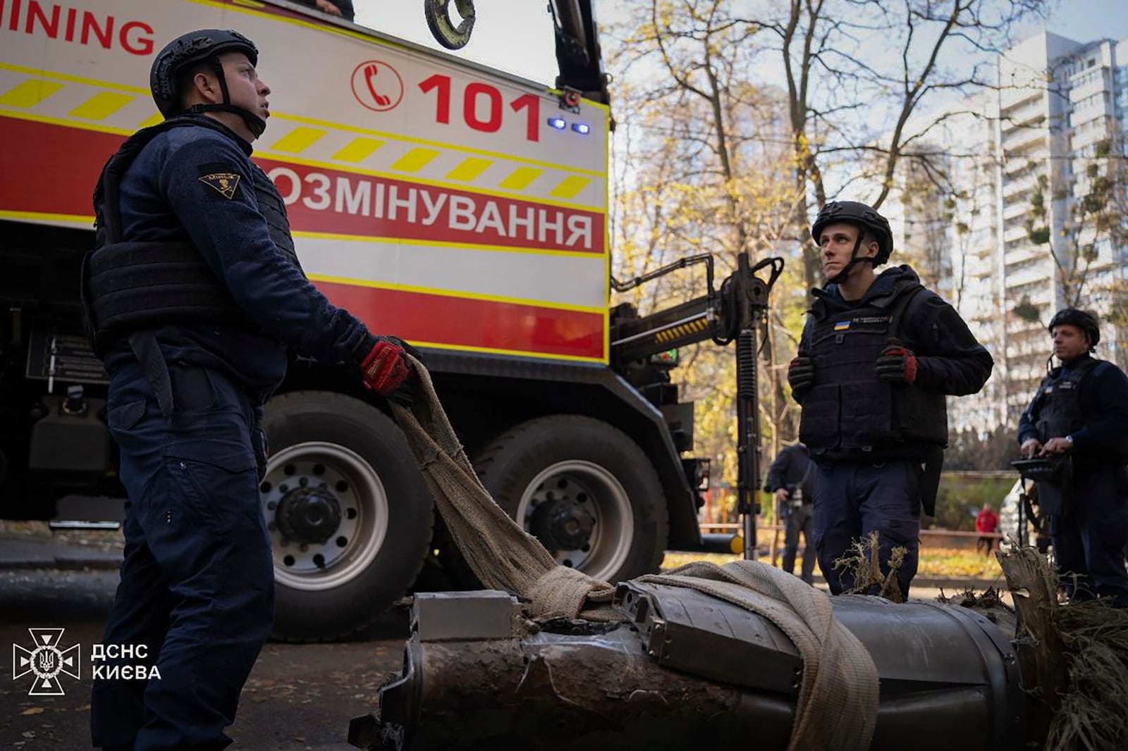 In this photo provided by the Ukrainian Emergency Service, emergency services personnel remove part of a Russian missile that hit an apartment house during massive missile attack in Kyiv, Ukraine, Sunday, Nov. 17, 2024. (Ukrainian Emergency Service via AP)