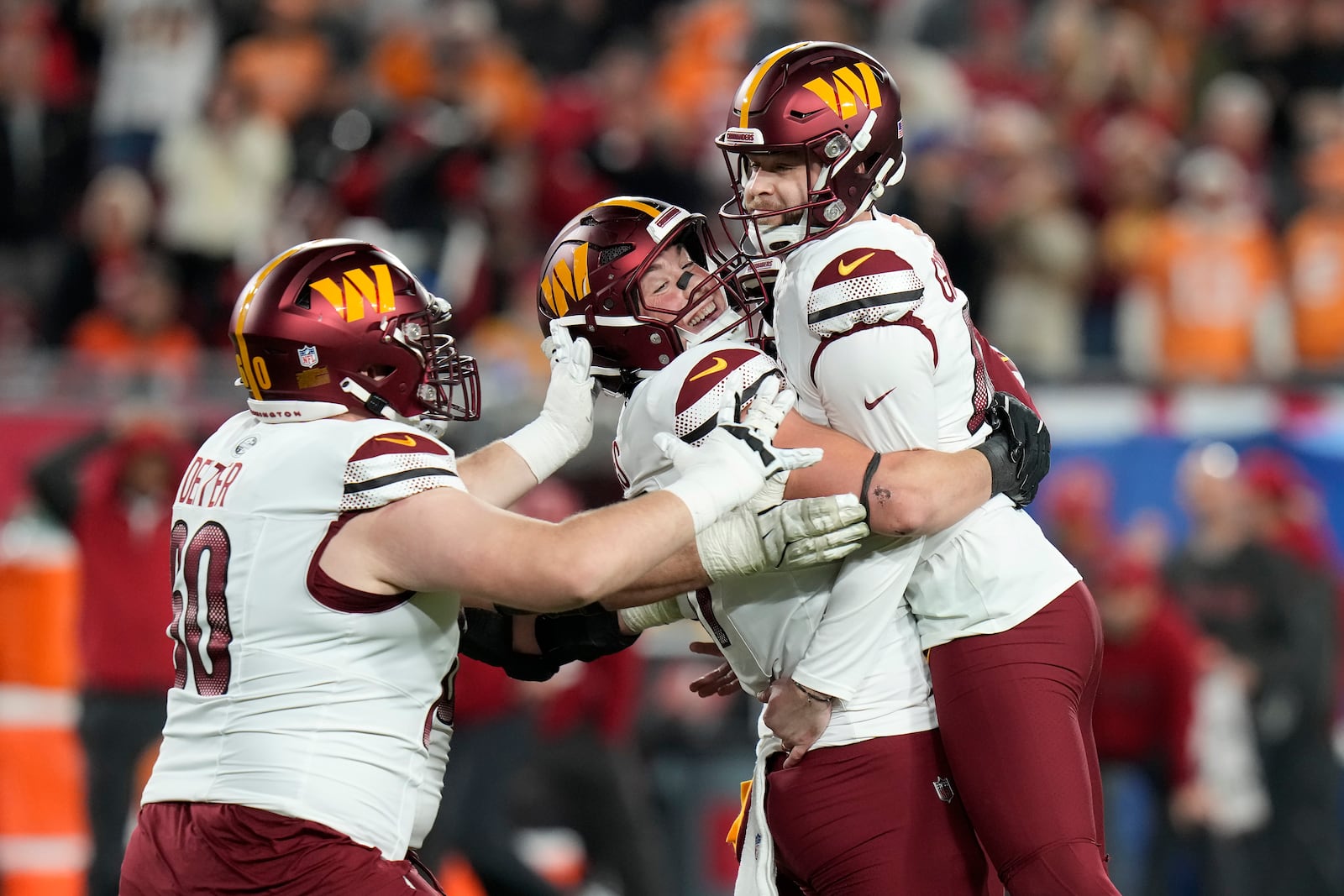 Washington Commanders place kicker Zane Gonzalez, right, is congratulated by teammates after kicking the game winning field goal against the Tampa Bay Buccaneers during the second half of an NFL wild-card playoff football game in Tampa, Fla., Sunday, Jan. 12, 2025. (AP Photo/Chris O'Meara)