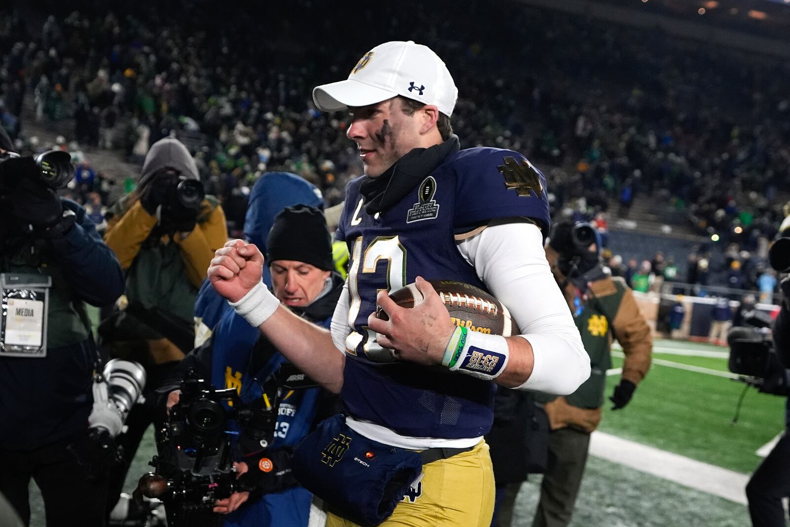 Notre Dame quarterback Riley Leonard (13) pumps his fist while leaving the field after the first round of the NCAA College Football Playoff against Indiana, Friday, Dec. 20, 2024, in South Bend, Ind. (AP Photo/Darron Cummings)