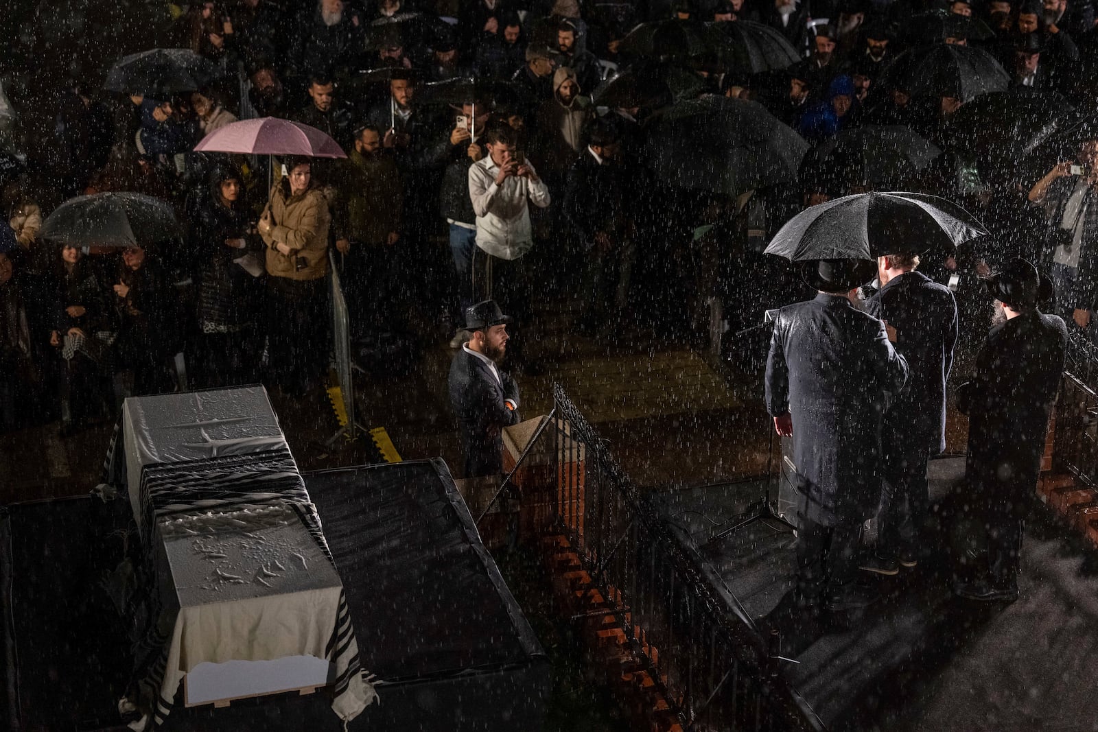 A rabbi delivers a eulogy next to the coffin containing the remains of Israeli-Moldovan Rabbi Zvi Kogan in Kfar Chabad, Israel, on Monday, November 25, 2024. Kogan, 28, an ultra-Orthodox rabbi, was killed last week in Dubai, where he ran a kosher grocery store. Israelis have increasingly traveled to Dubai for business and tourism since the two countries established diplomatic ties through the 2020 Abraham Accords.(AP Photo/Ohad Zwigenberg)