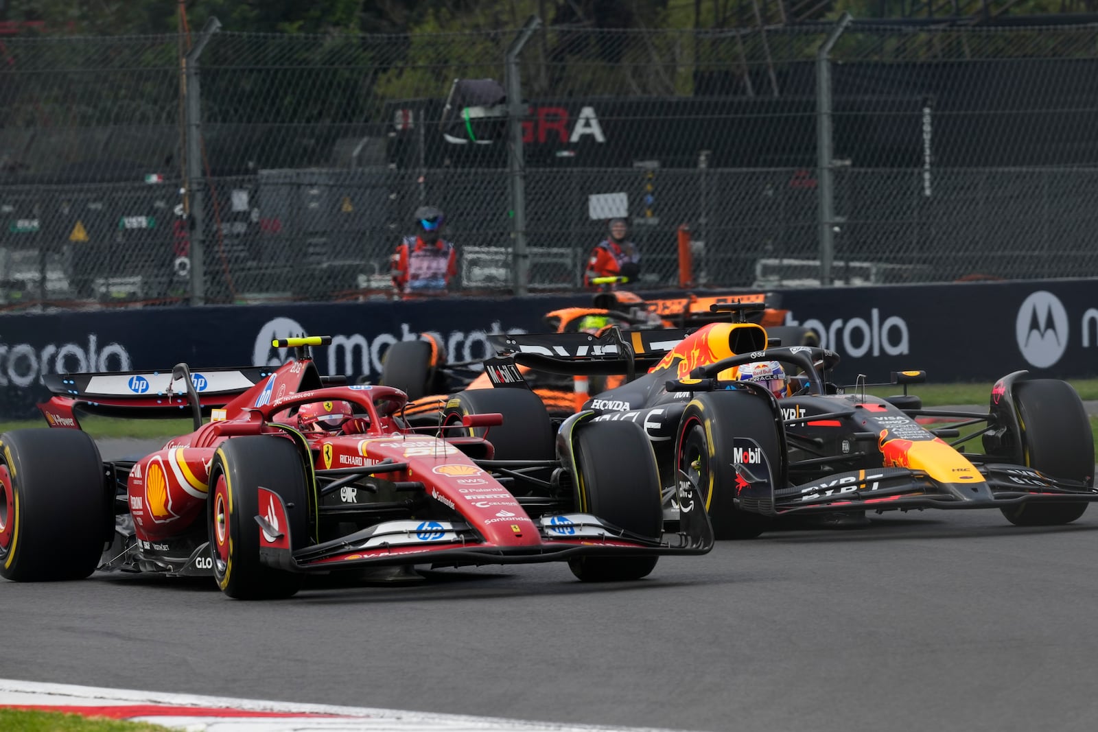 Carlos Sainz, of Spain, steers his Ferrari followed by Red Bull driver Max Verstappen of the Netherlands during the Formula One Mexico Grand Prix auto race at the Hermanos Rodriguez racetrack in Mexico City, Sunday, Oct. 27, 2024. (AP Photo/Moises Castillo)