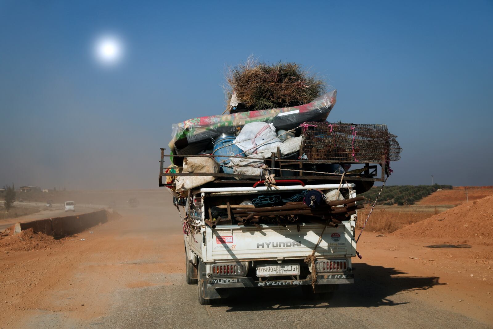 Civilians carrying their belongings leave the area as Syrian opposition fighters confront government troops, in the village of Suran, north of Hama, Syria, Tuesday Dec. 3, 2024.(AP Photo/Ghaith Alsayed)