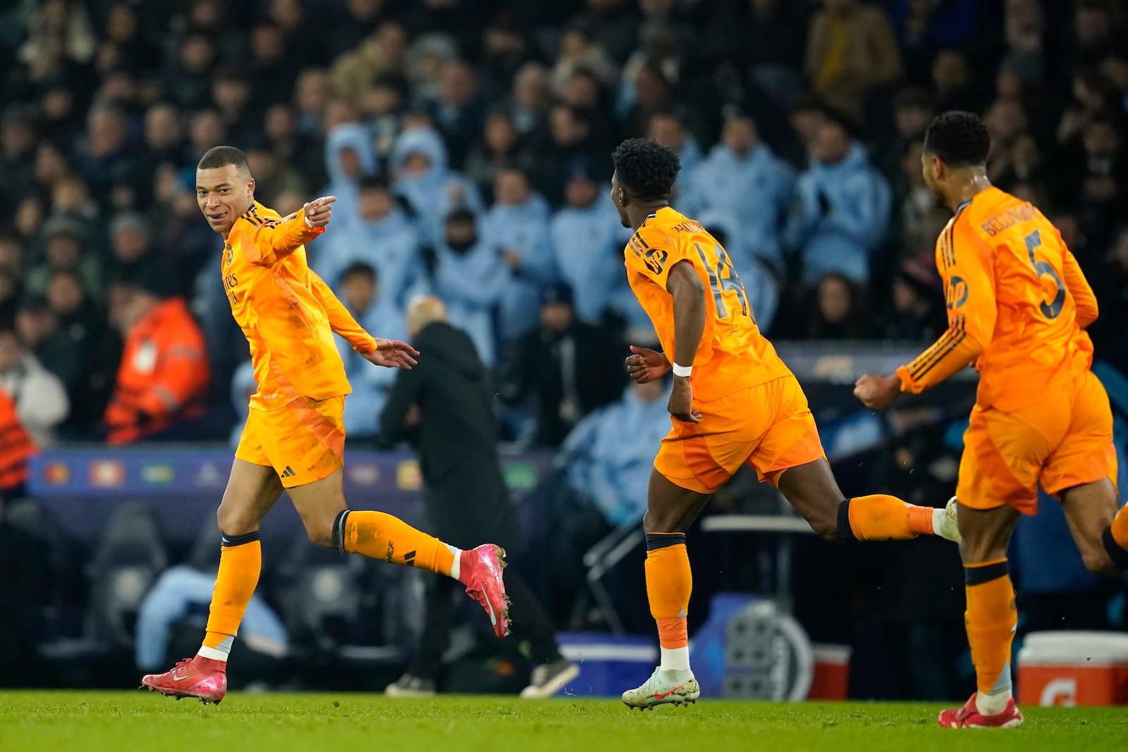 Real Madrid's Kylian Mbappe, left, runs to celebrate after socring his sides first goal during the Champions League playoff first leg soccer match between Manchester City and Real Madrid at the Etihad Stadium in Manchester, England, Tuesday, Feb. 11, 2025. (AP Photo/Dave Thompson)