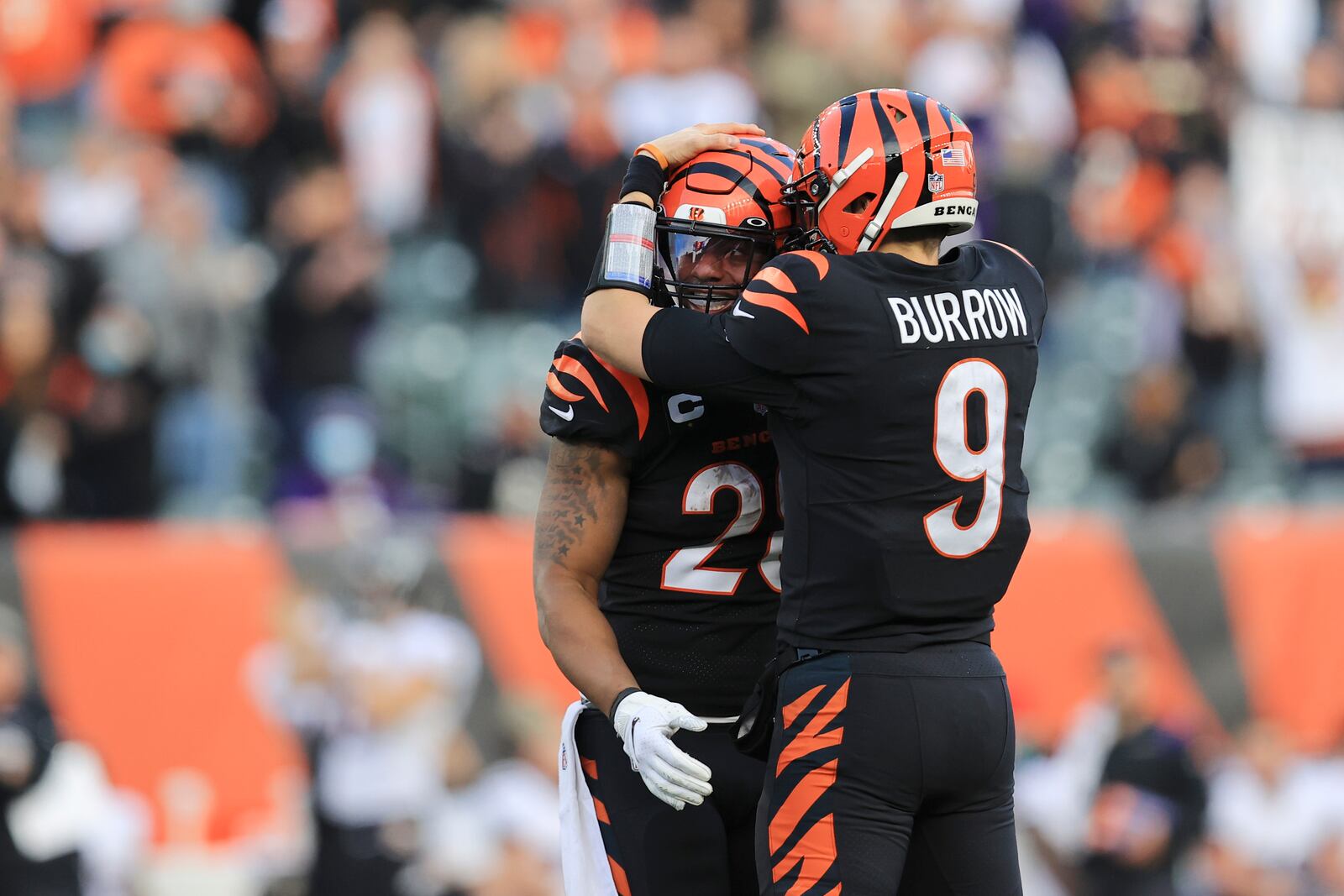 Cincinnati Bengals quarterback Joe Burrow (9) hugs Joe Mixon (28) following a catch by Mixon during the second half of an NFL football game against the Baltimore Ravens, Sunday, Dec. 26, 2021, in Cincinnati. (AP Photo/Aaron Doster)