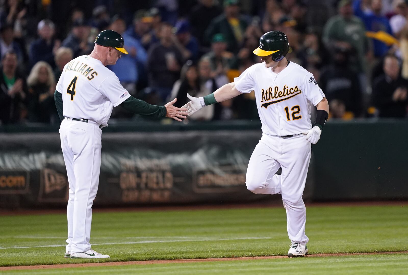 OAKLAND, CALIFORNIA - SEPTEMBER 04: Sean Murphy #12 of the Oakland Athletics is congratulated by third base coach Matt Williams #4 after Murphy hit a solo home run against the Los Angeles Angels of Anaheim in the bottom of the fifth inning at Ring Central Coliseum on September 04, 2019 in Oakland, California. The home run was Murphy's first career hit. (Photo by Thearon W. Henderson/Getty Images)