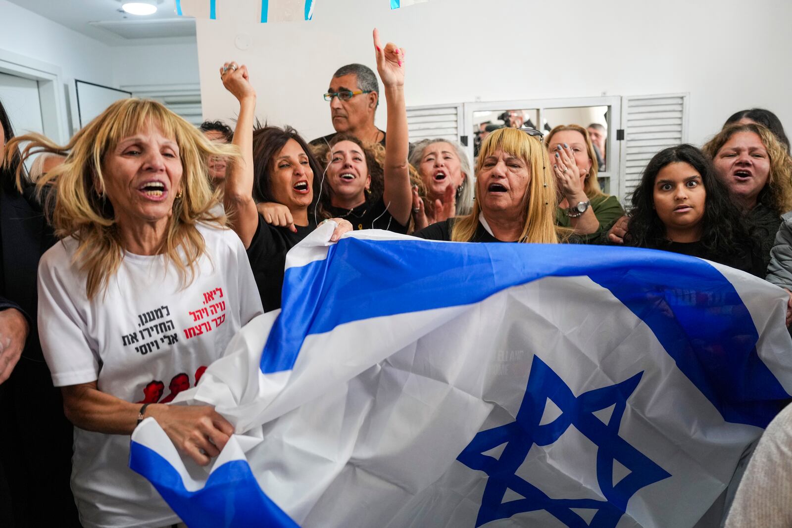 Family of Israeli hostage Eli Sharabi, whose wife and two daughters were killed on Oct. 7 attack, react as they watch the live broadcast of him being released from Hamas captivity in Gaza, in Tel Aviv, Israel, Saturday, Feb. 8, 2025, as part of the Israel-Hamas ceasefire deal. (AP Photo/Ariel Schalit)