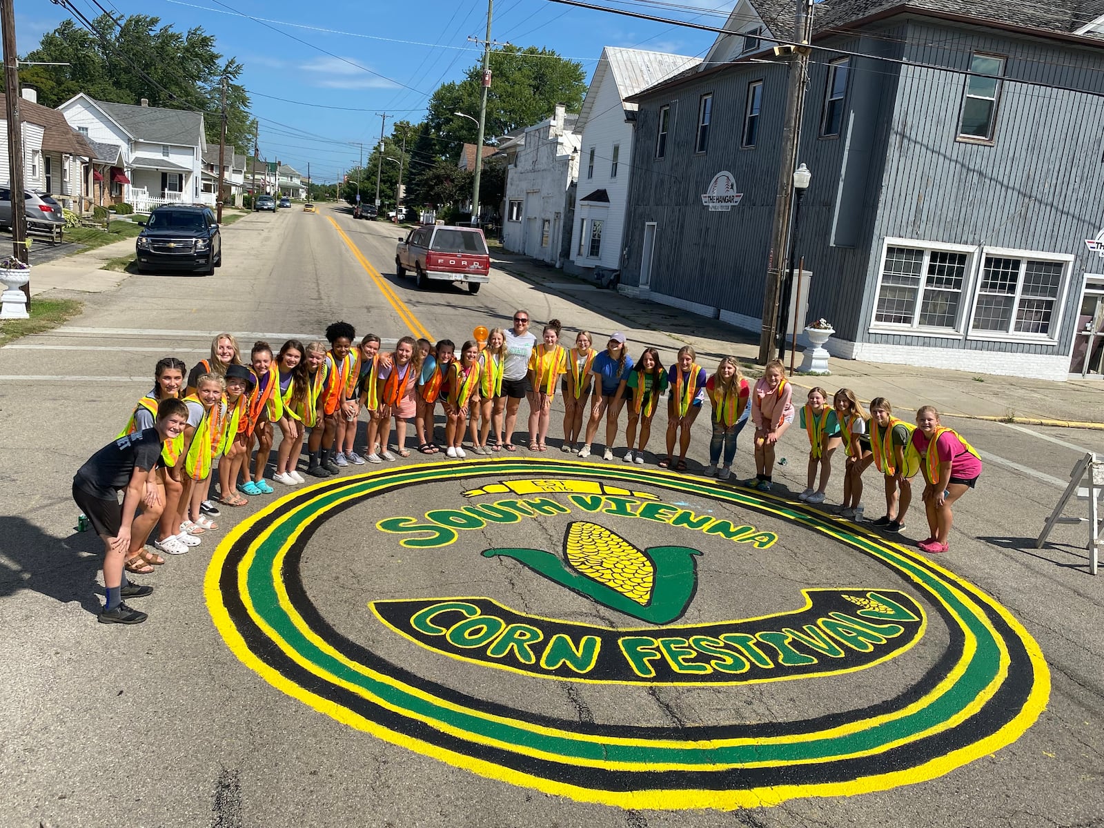 Members of the Northeastern cheerleading program helped organizers prepare for the 44th annual South Vienna Corn Festival by painting the logo and other items for the event's return this weekend. Contributed photo