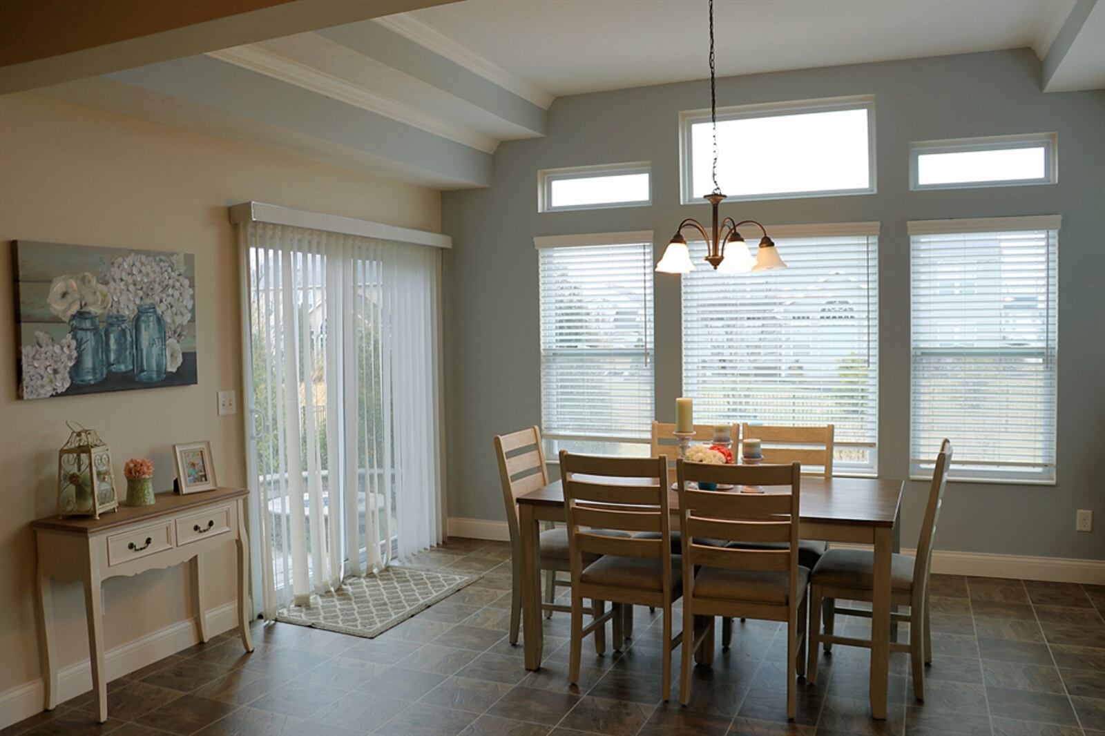 Currently set up as a breakfast area, the morning room has a double tray ceiling and a wall of rectangular windows.