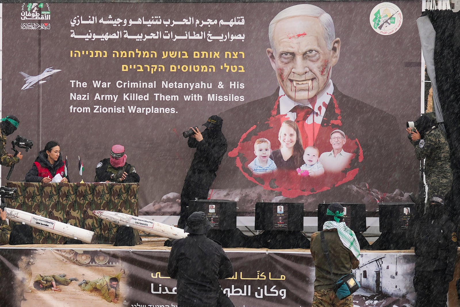 Hamas fighters hand over the coffins containing the bodies of four Israeli hostages, including a mother and her two children, who had long been feared dead, to the Red Cross in Khan Younis, southern Gaza Strip, Thursday, Feb. 20, 2025. (AP Photo/Abdel Kareem Hana)