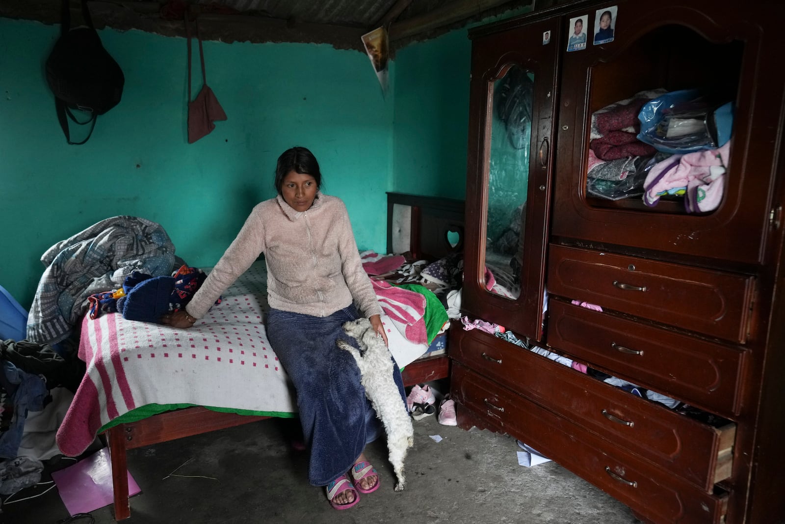 Gloria Llugsha pets her dog during an interview about the Indigenous vote ahead of the presidential run-off election in Cochapamba, Ecuador, Tuesday, Feb. 11, 2025. (AP Photo/Dolores Ochoa)