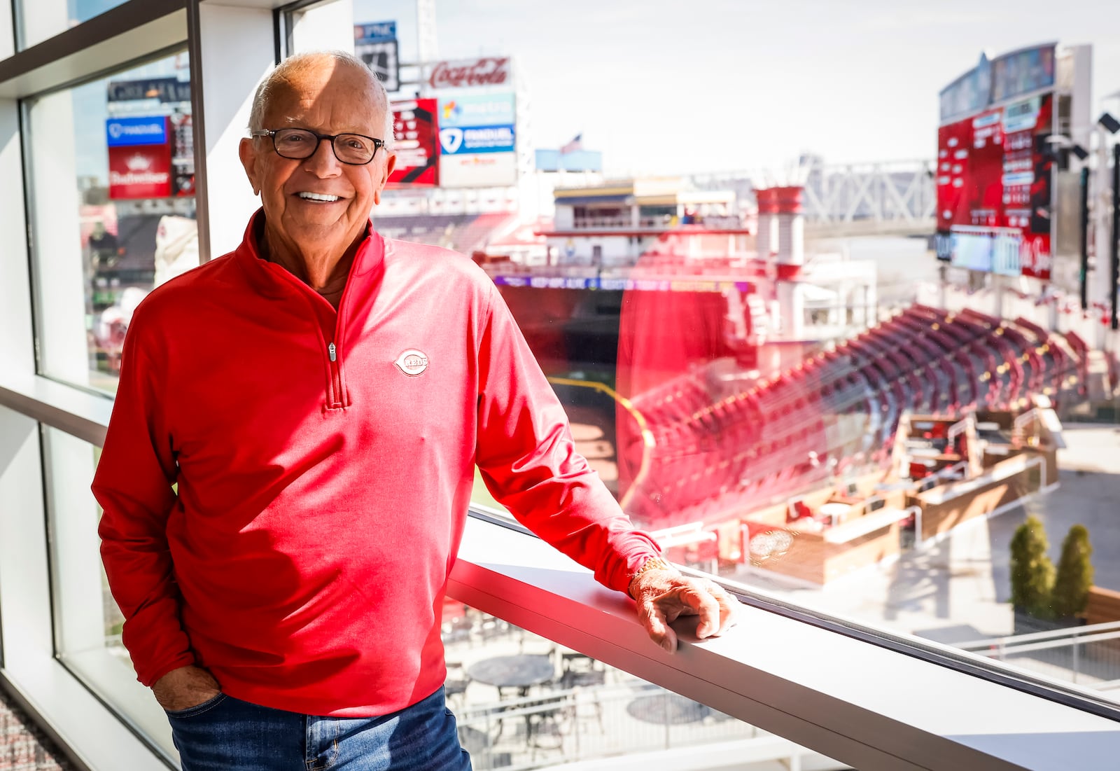 Long time Reds broadcaster Marty Brennaman stands with the Great American Ball Park in the background. Brennaman will be honored with a bronze statue outside the park on Saturday, Sept. 6, 2025. NICK GRAHAM/STAFF