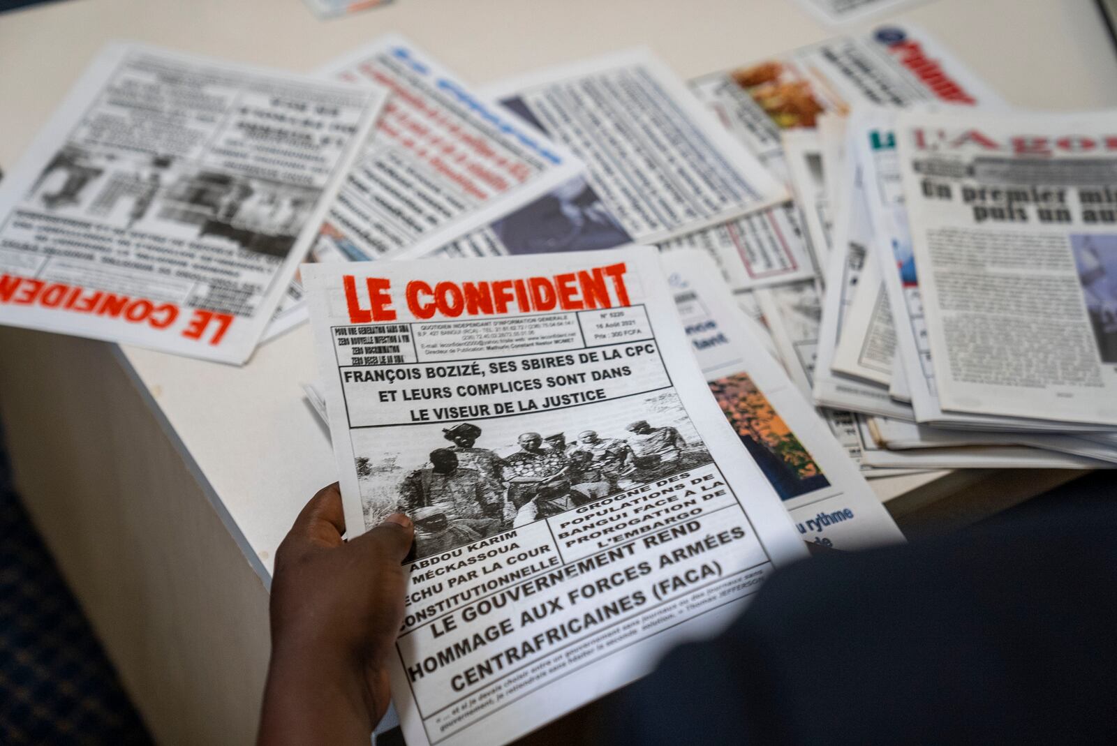 Whistleblower Ephrem Yaline-Ngonzo, who was recruited by Kremlin-backed Wagner forces to spread Russian propaganda in Central African Republic, sorts through CAR newspapers during a visit in Johannesburg, South Africa, Nov. 2, 2022. (Forbidden Stories via AP)