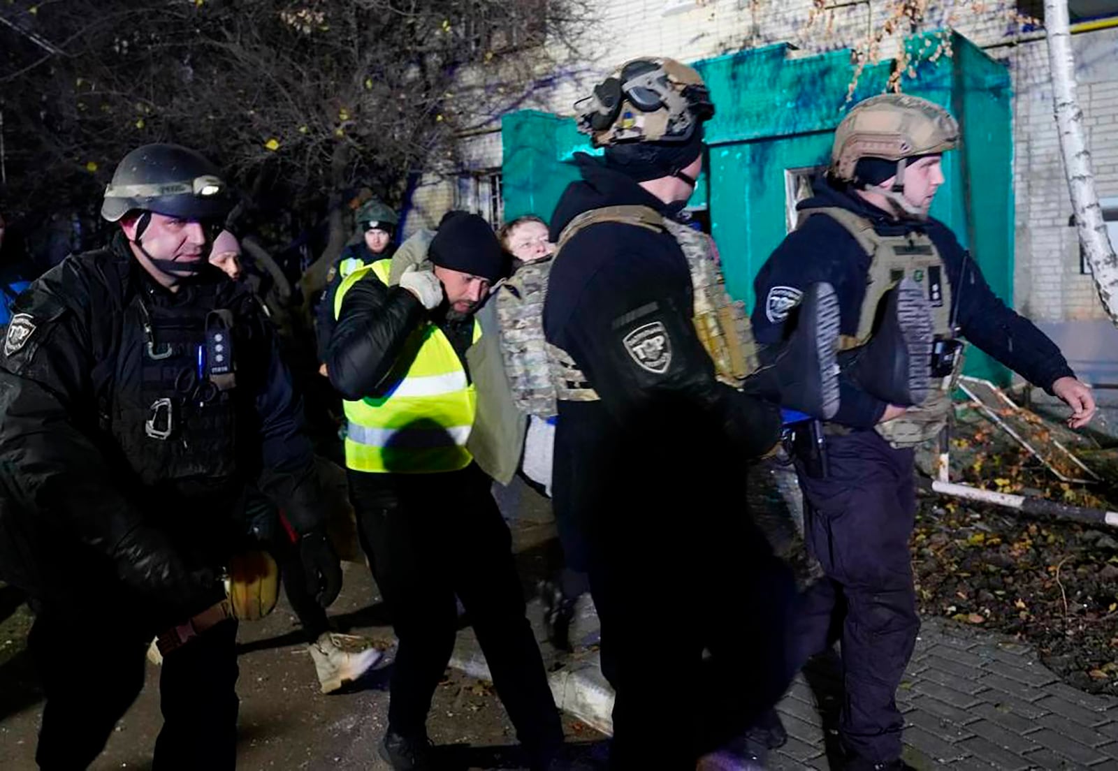 In this photo provided by the Ukrainian Emergency Service, police officers evacuate an injured resident following a Russian rocket attack that hit a multi-storey apartment building in Sumy, Ukraine, Sunday, Nov. 17, 2024. (Ukrainian Emergency Service via AP)