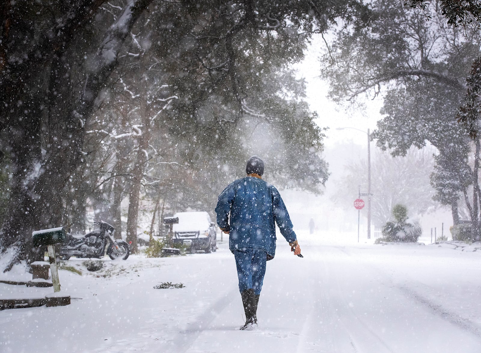 Michael Peterson walks down a snowy street in the League City Historic District in League City, Texas on Tuesday, Jan. 21, 2025. (Stuart Villanueva/The Galveston County Daily News via AP)