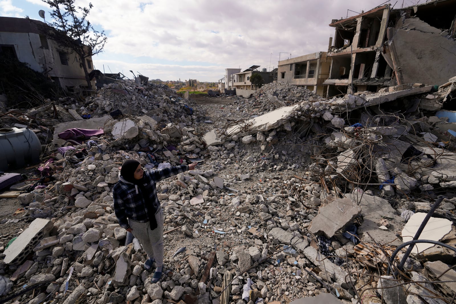 A woman inspects buildings destroyed in Israeli airstrikes in Baalbek, eastern Lebanon, Thursday, Nov. 28, 2024. (AP Photo/Hassan Ammar)