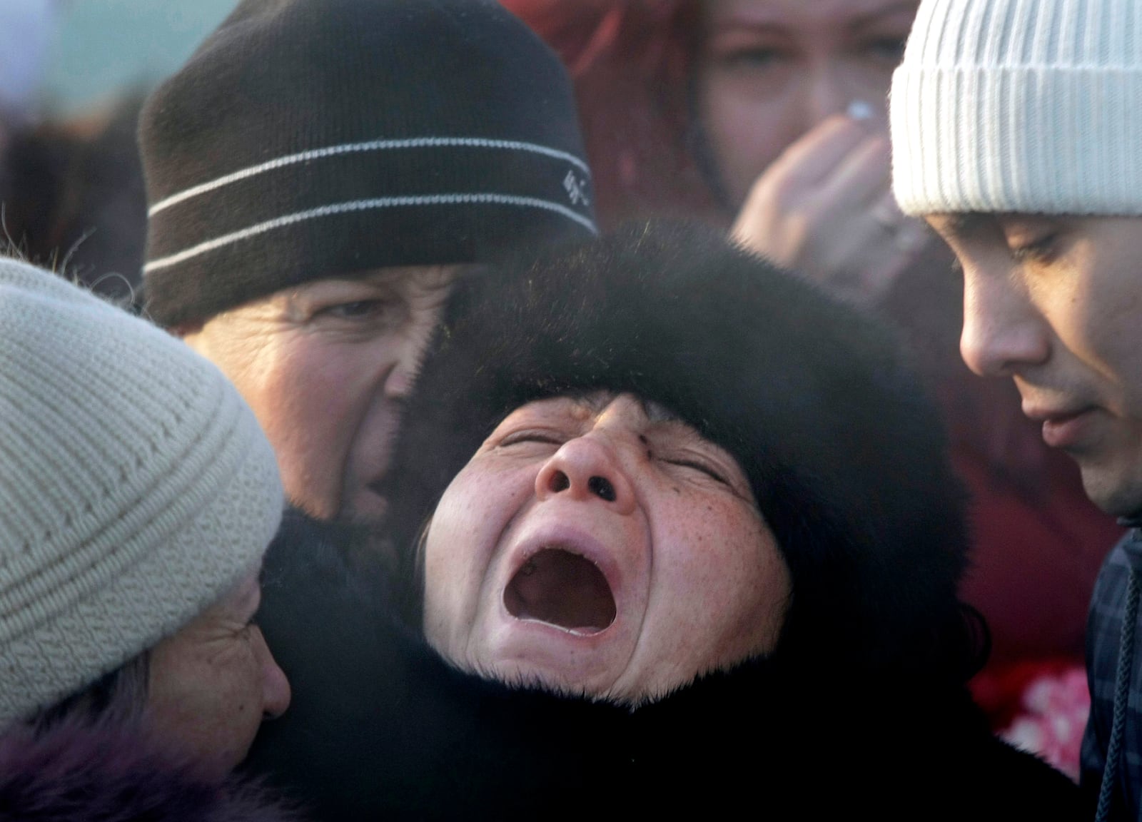 FILE - Mother of Liliya Kalashnikova, a victim of the night club fire, center, no name given, cries at her daughter's funeral at a cemetery in the Ural Mountains city of Perm, about 1,200 km (700 miles) east of Moscow, Monday, Dec. 7, 2009. (AP Photo/Mikhail Metzel, File)