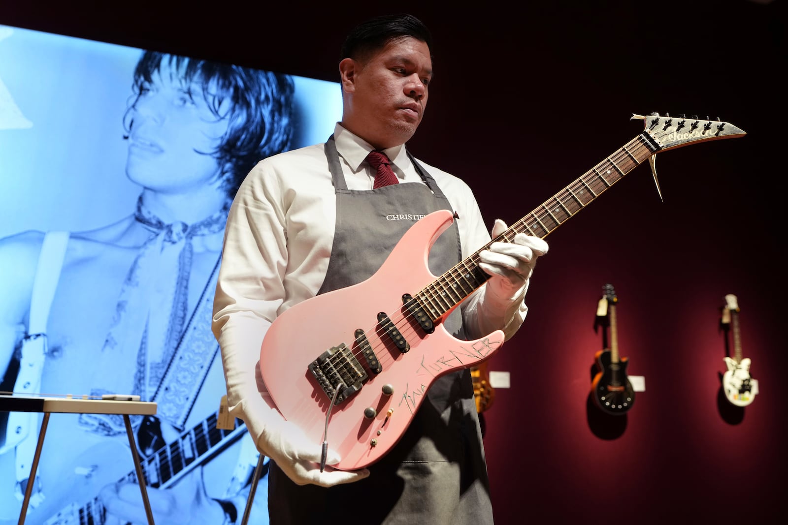 An art handler displays a Jackson, Glendora, California, 1983, a solid-body electric guitar, soloist, signed by Tina Turner, ahead of the pre-sale exhibition of Jeff Beck The Guitar Collection at Christie's auction rooms in London, Tuesday, Jan. 14, 2025. (AP Photo/Kirsty Wigglesworth)