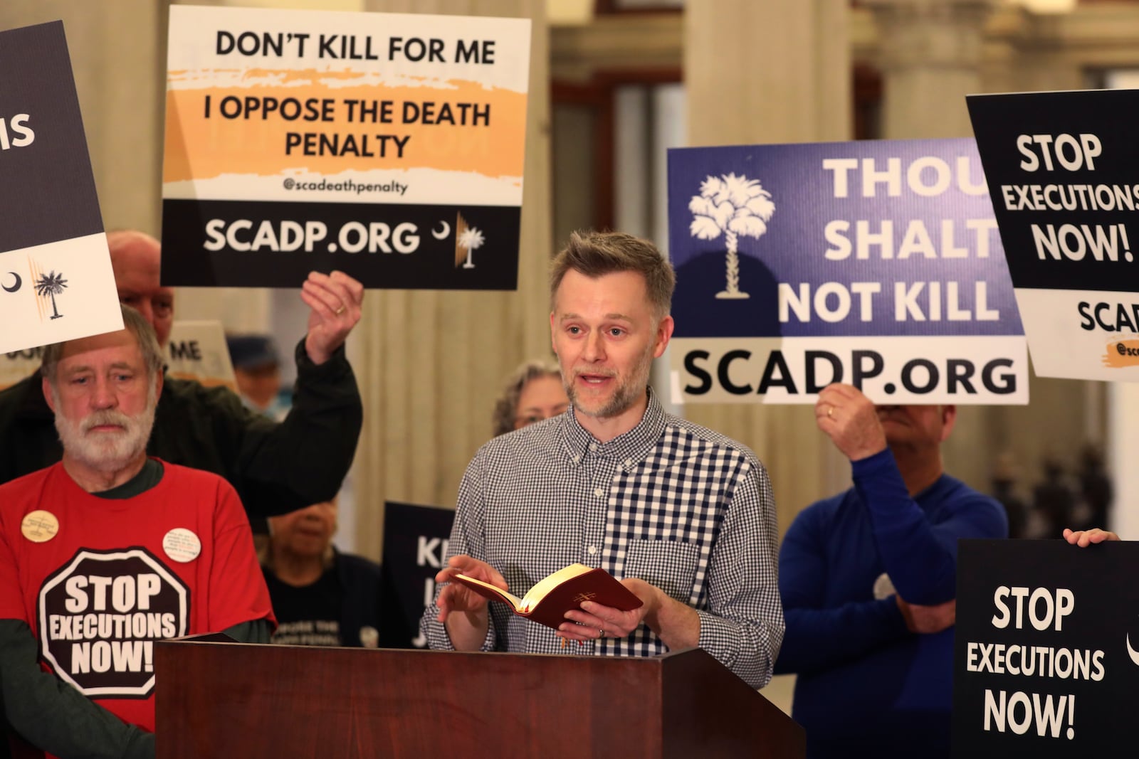 Sam Heath of Equal Justice USA reads scripture before the South Carolinians for Alternatives to the Death Penalty presented a petition to stop the firing squad execution of Brad Sigmon to the South Carolina governor's office on Thursday, March 6, 2025, in Columbia, S.C. (AP Photo/Jeffrey Collins)